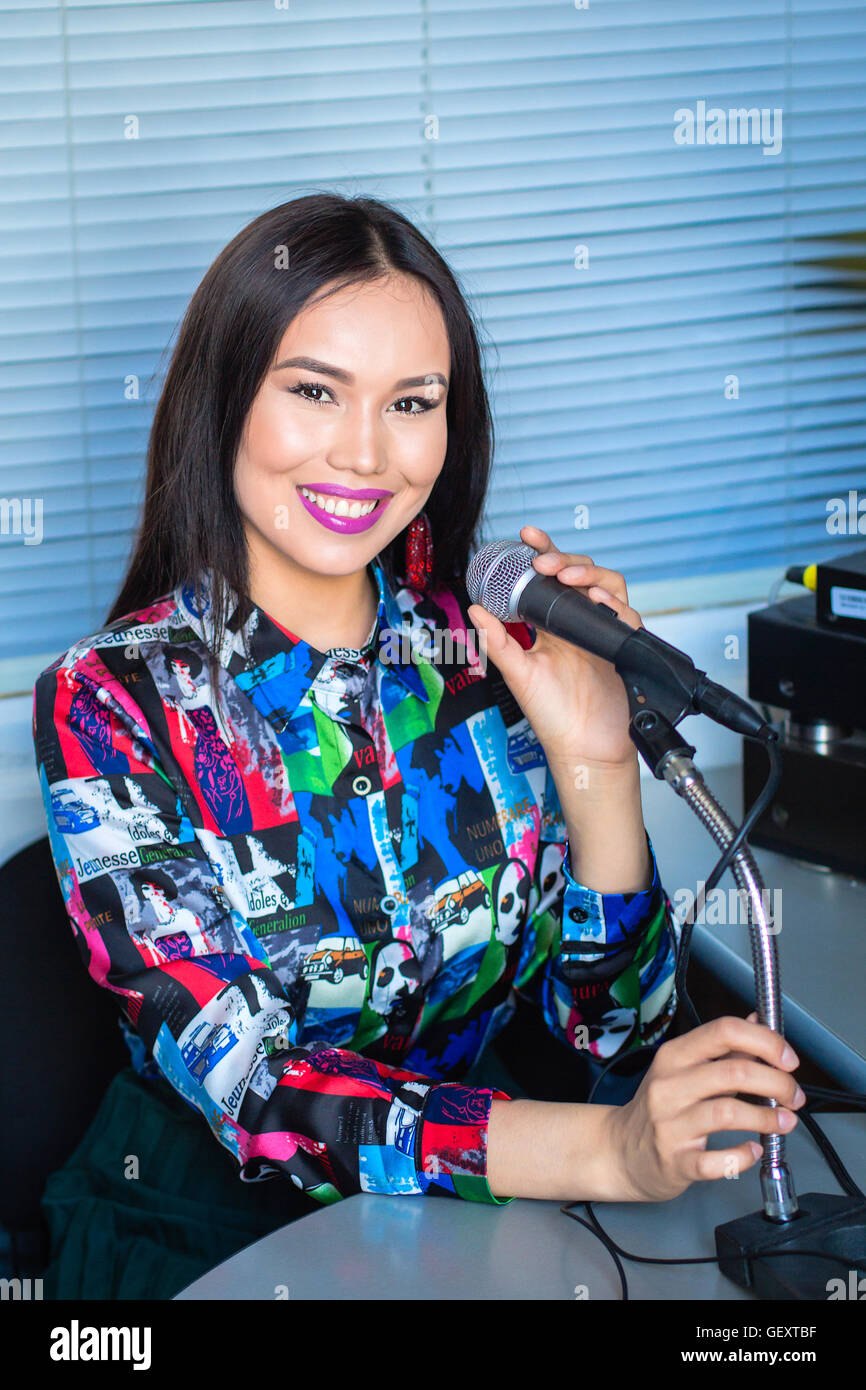 Fille dans un casque avec un micro à la radio dans le studio Banque D'Images