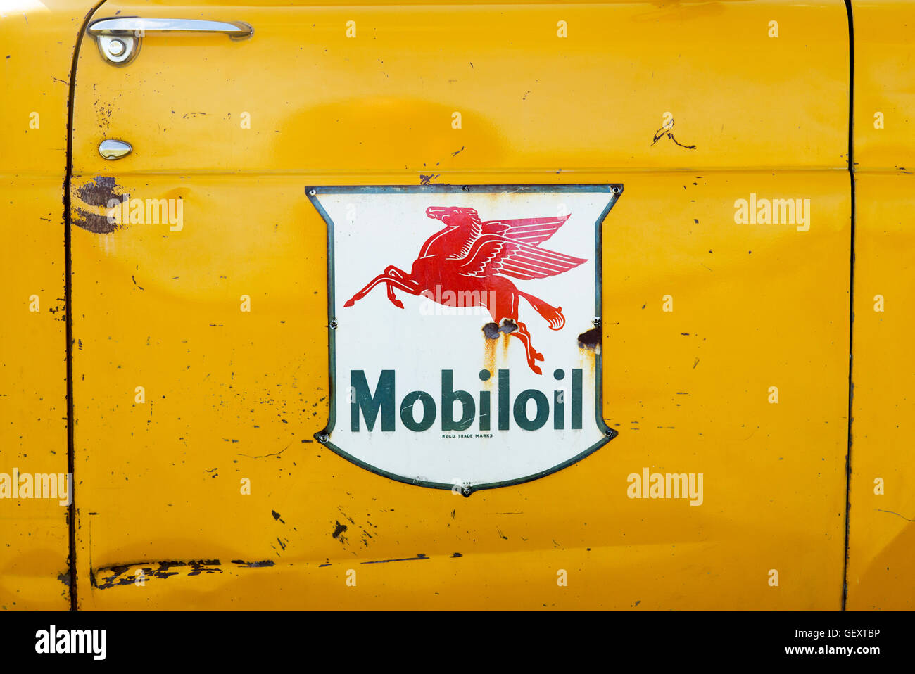 Vintage Mobil oil signe sur le côté d'un camion américain jaune porte Banque D'Images