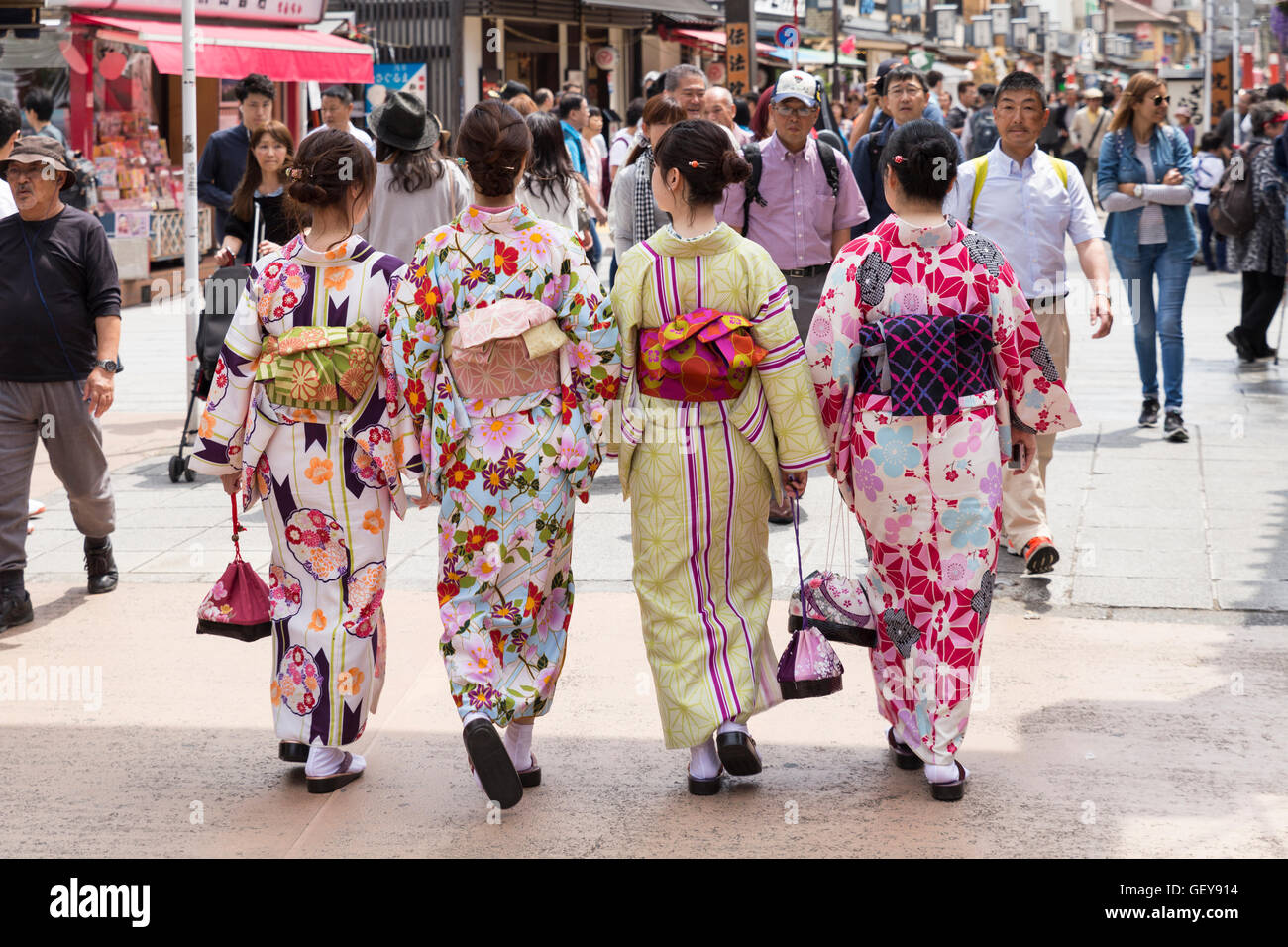 Quatre jeunes femmes portant des robes traditionnelles japonaises se promener ensemble à travers les petites rues autour de Senso-ji temple, Tokyo Banque D'Images