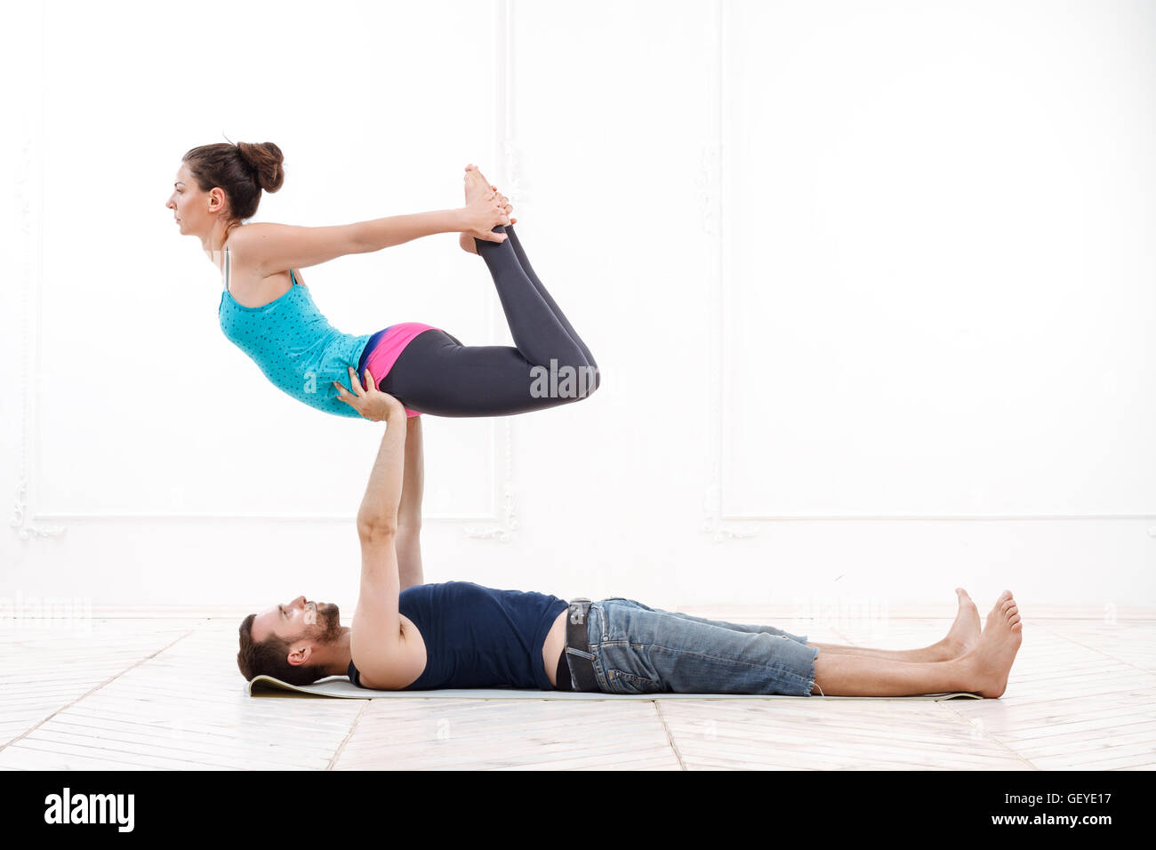 Belle jeune couple Practicing Acro-Yoga Banque D'Images
