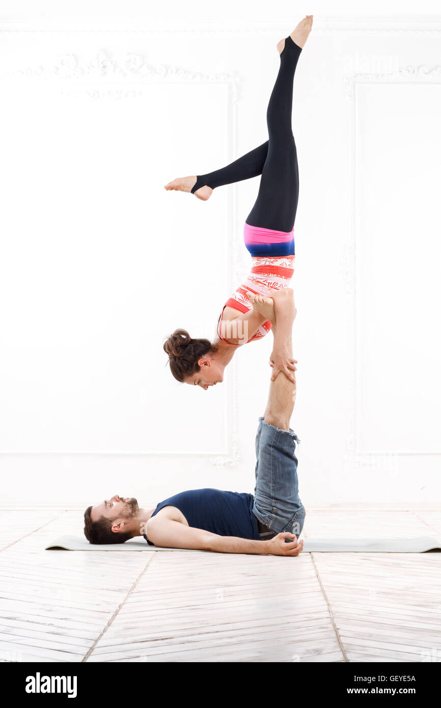 Belle jeune couple Practicing Acro-Yoga Banque D'Images
