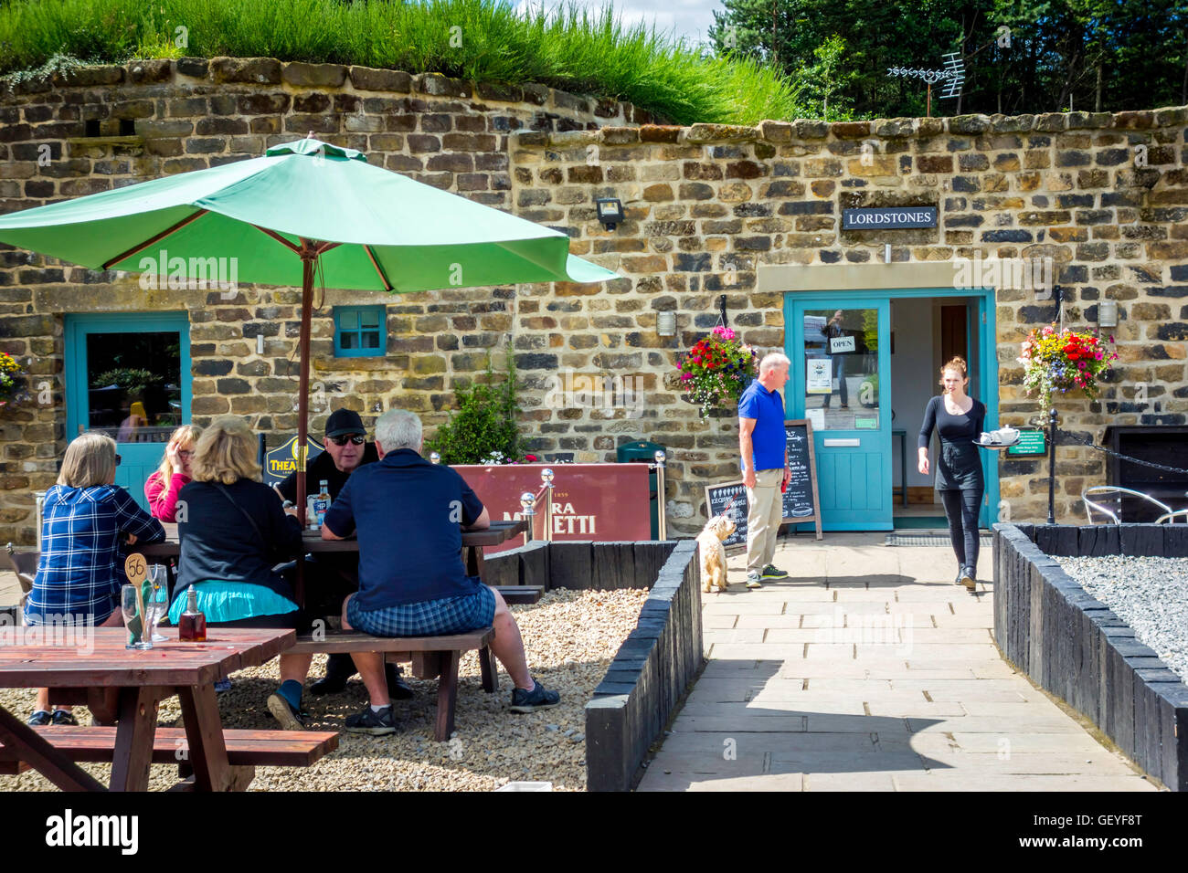 Un groupe familial bénéficiant d'ensoleillement, un homme avec un chien et un plateau noodles au Seigneur Stones café North Yorkshire Moors Banque D'Images