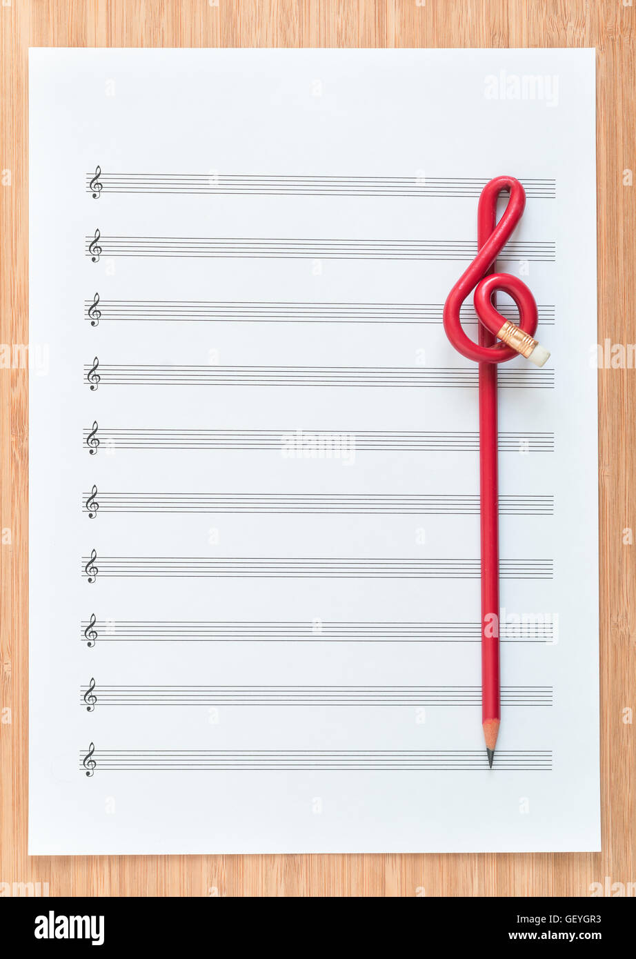 Feuille vierge music fin un crayon rouge en forme de clé de sol. Banque D'Images