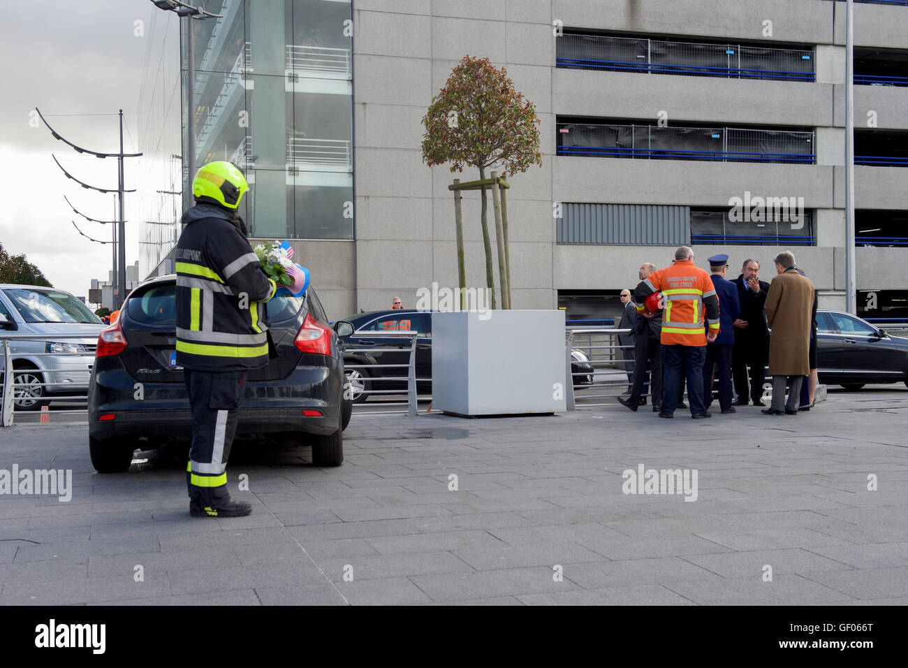 Un pompier portant une couronne s'en tant que Secrétaire Kerry est arrivé à l'aéroport de Bruxelles National à visiter le terminal attaqué par des terroristes le 22 mars Banque D'Images