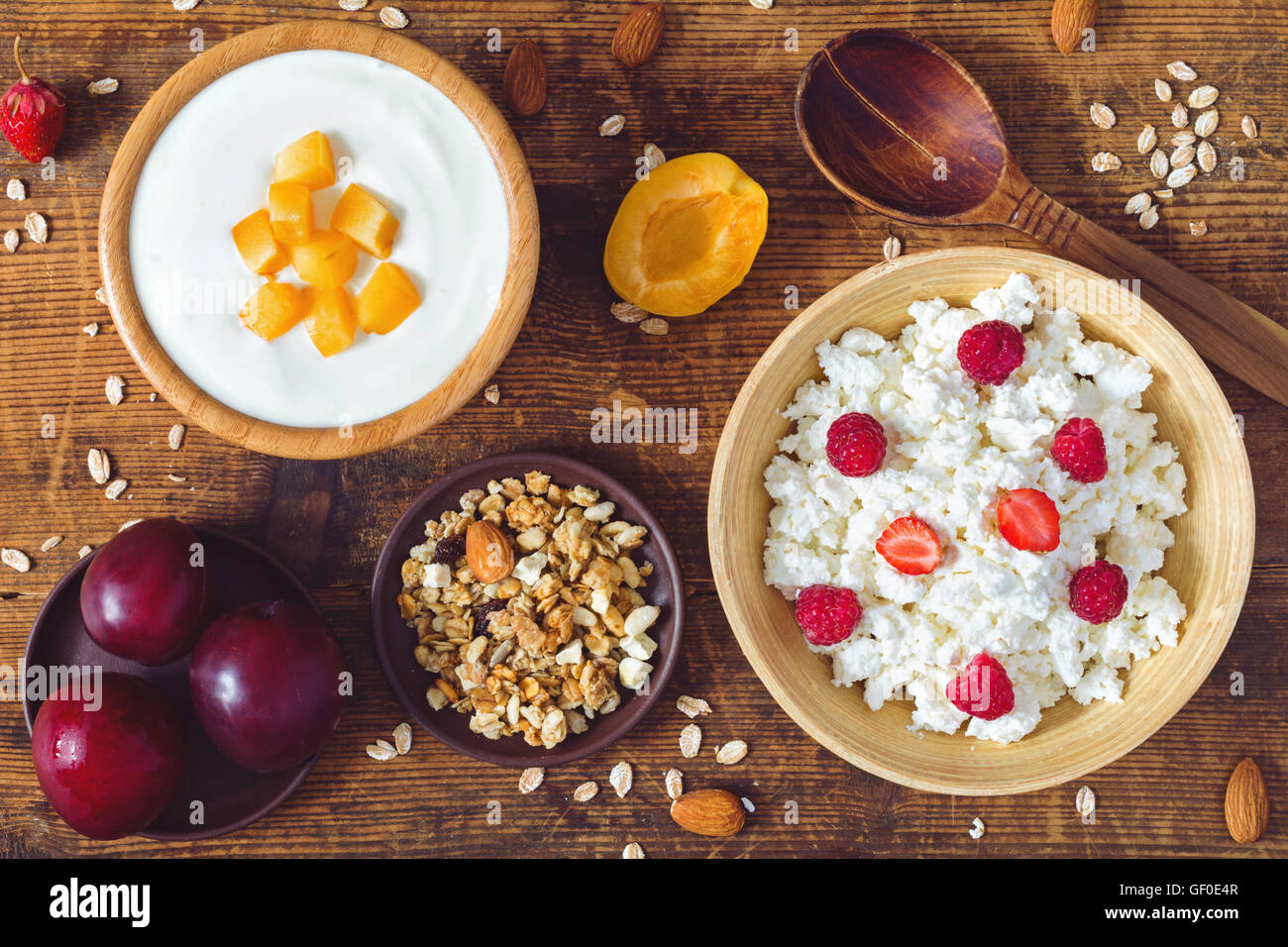 Le fromage blanc, yaourts, muesli, céréales et fruits frais sur fond de bois. Petit-déjeuner sain, l'alimentation Banque D'Images