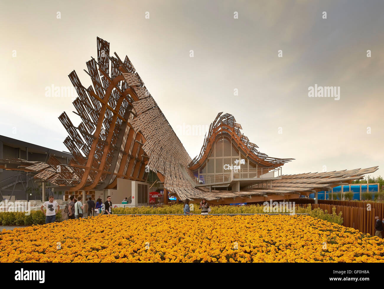 Approche avec lits de fleurs et de toit ondulé. Milan EXPO 2015, Pavillon de la Chine, Milan, Italie. Architecte : Studio Link-Arc avec l'Université de Tsinghua, 2015. Banque D'Images