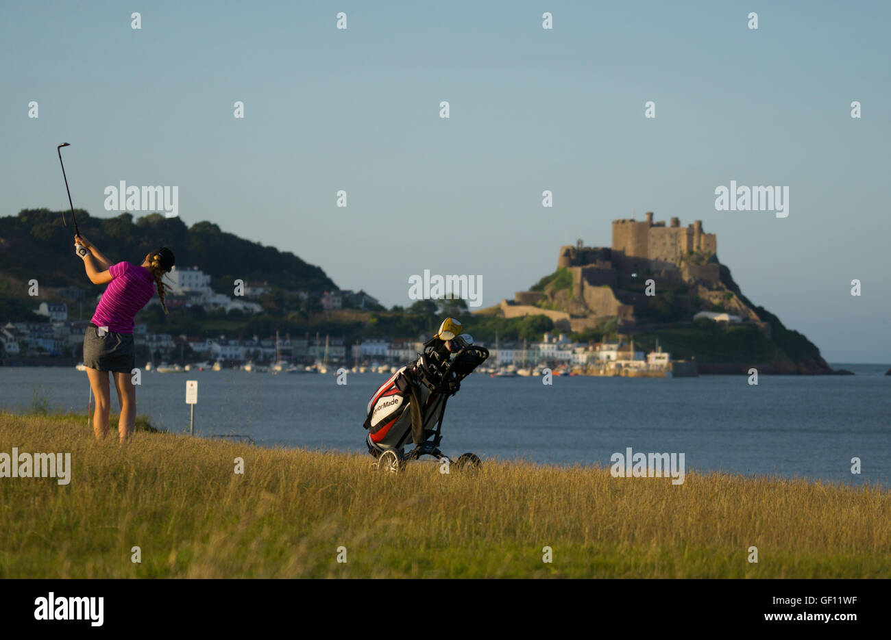 Un golfeur Dame prend un coup à Gorey Castle dans l'arrière-plan. Banque D'Images