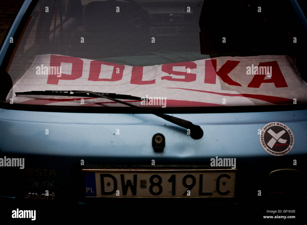 Une voiture avec un drapeau polonais à l'intérieur de celui-ci à Wroclaw, Pologne. Banque D'Images