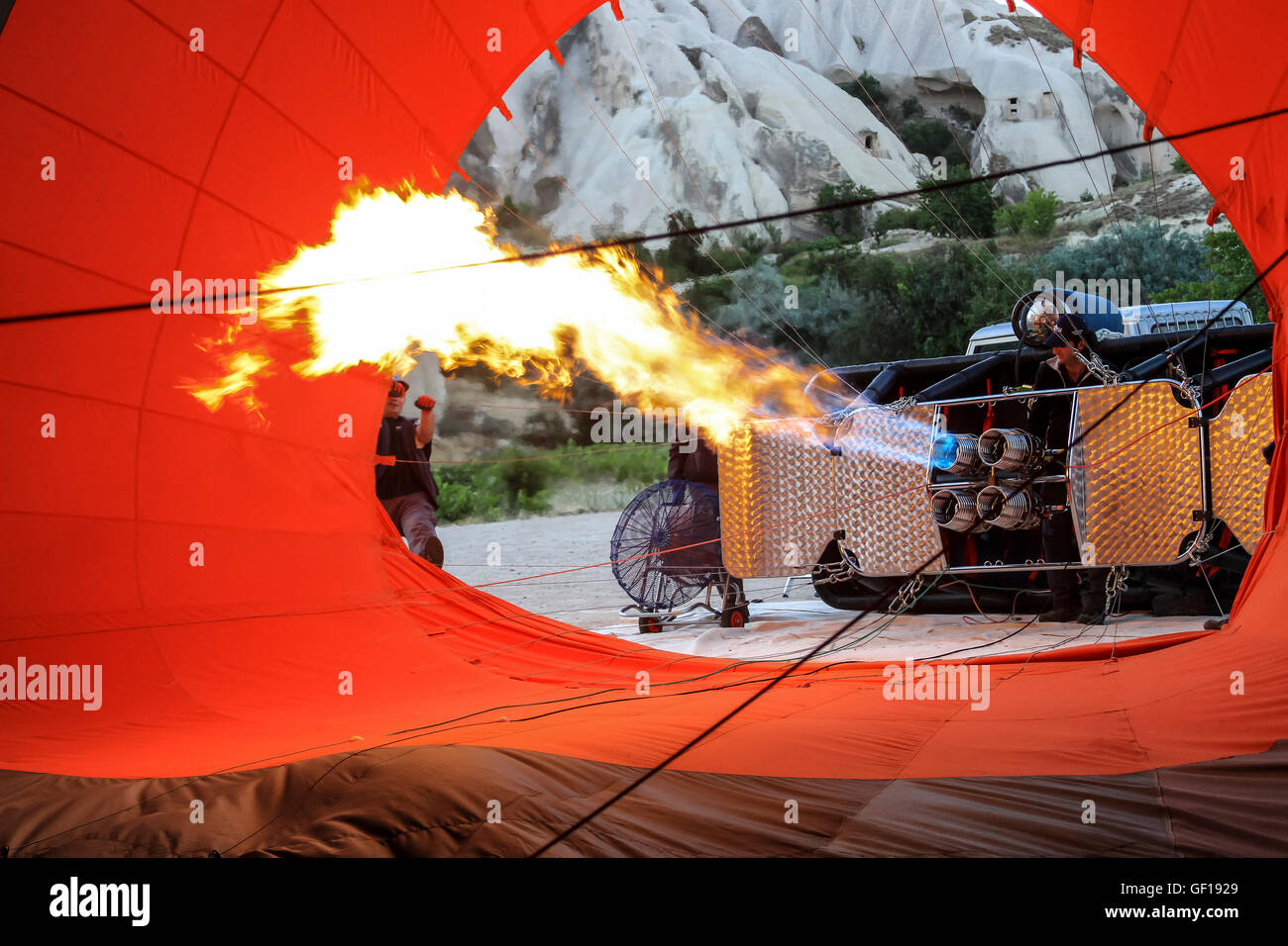 Cappadoce, Turquie. Juillet 2012. Deux hommes l'obtention d'un ballon à air chaud prêt à voler sur les cheminées de fées. Banque D'Images