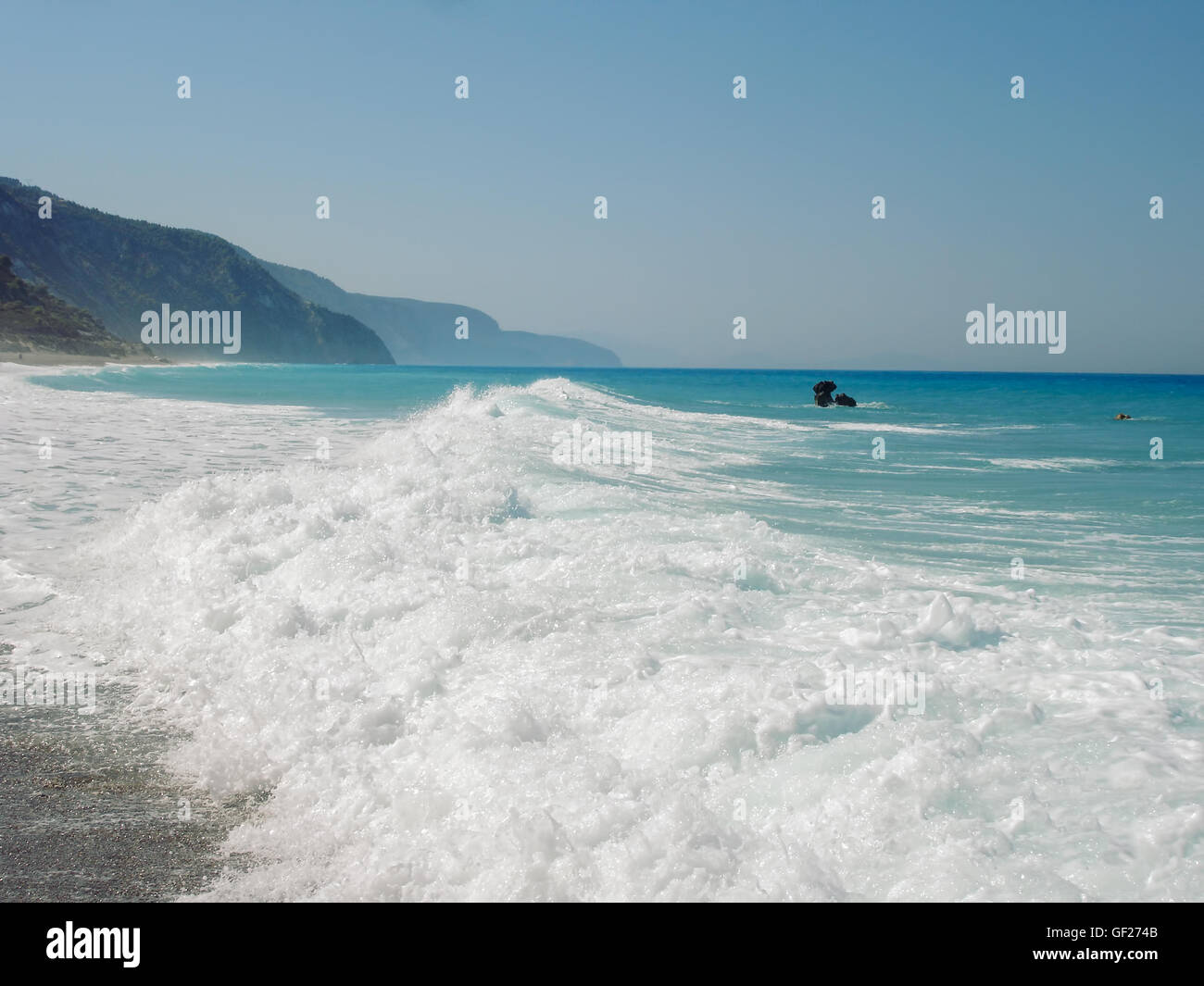 Plage sauvage sur l'île de Leucade en Grèce, de l'eau se brisant sur les rochers en arrière-plan sur l'île de Lefkada ach Banque D'Images