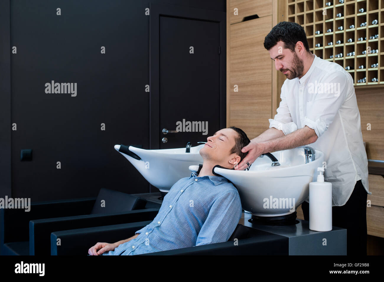Hairstylist Coiffure Cheveux Client Laver - Young Man Relaxing In Hairdressing Salon de Banque D'Images
