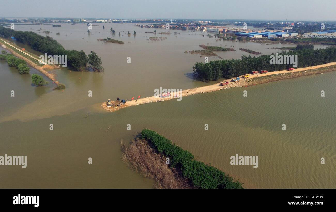 Xiaogan, province du Hubei en Chine. 28 juillet, 2016. Les véhicules transportant des travailleurs des pierres pour fermer la brèche de la digue de la rivière dans Fuhuan Xiaogan, centre de la Chine, la province du Hubei, le 28 juillet 2016. Plus de 150 techniciens, 60 véhicules et huit grands équipements de construction ont été envoyés pour renforcer et fermer la digue a manqué. Credit : Rao Rao/Xinhua/Alamy Live News Banque D'Images