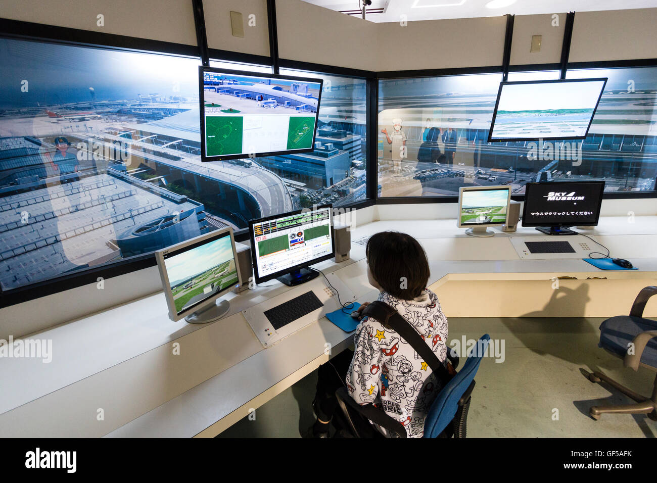 Le Japon, l'aéroport de Kansai, KIX. Musée du ciel, de l'intérieur. Caucasien enfant, garçon de 14 ans, assis à la circulation aérienne Contrôleur de vol simulateur. Banque D'Images
