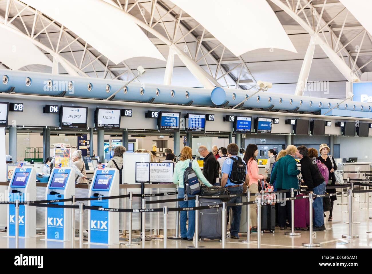 Le Japon, l'aéroport de Kansai, KIX. L'intérieur de l'aérogare 1. L'enregistrement international. Les touristes américains en attente à contrôler dans un bureau pour United airlines. Banque D'Images