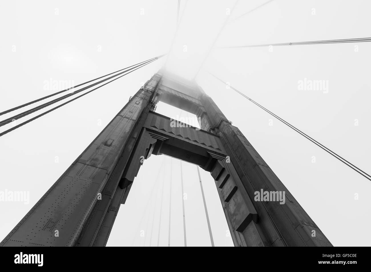 Golden Gate Bridge Tower qui sortent d'emblématique de la baie de San Francisco fog bank en noir et blanc. Banque D'Images