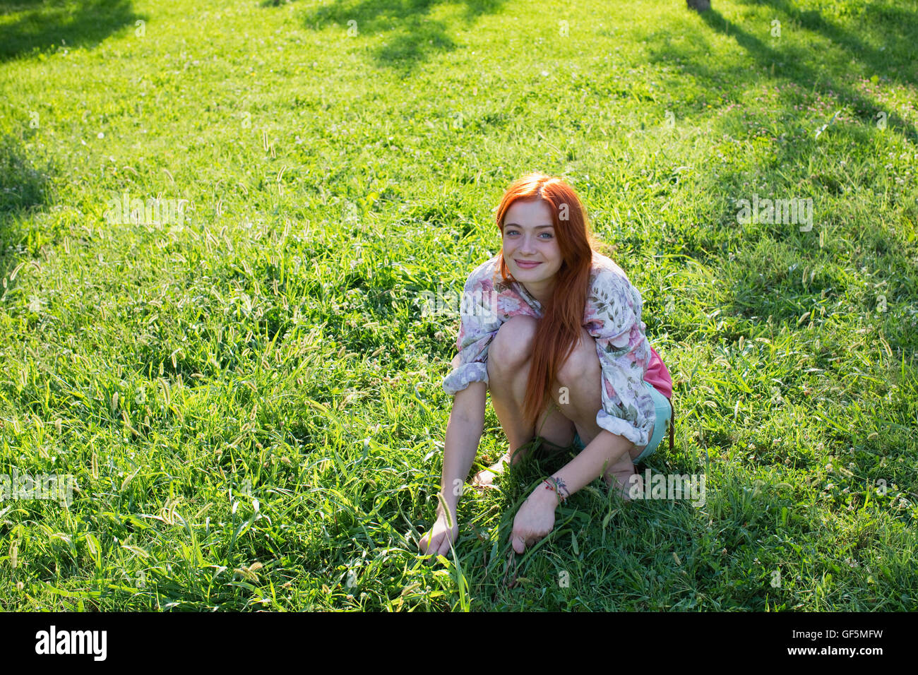 Portrait de jeune femme assise sur l'herbe. Banque D'Images