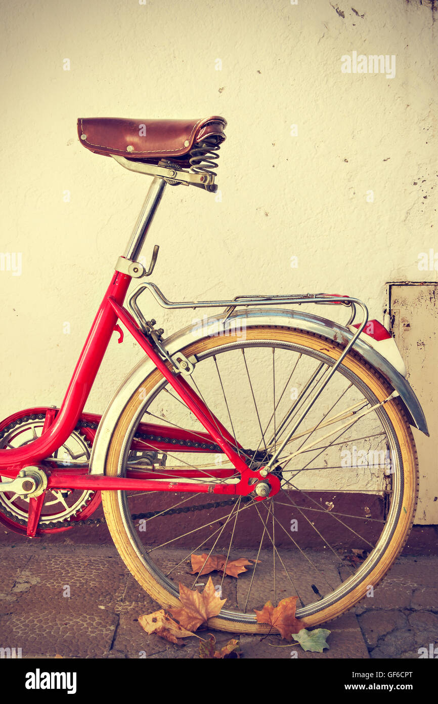 Vélo rétro avec les feuilles d'automne sur la roue arrière. Vintage style. Vertical image Banque D'Images