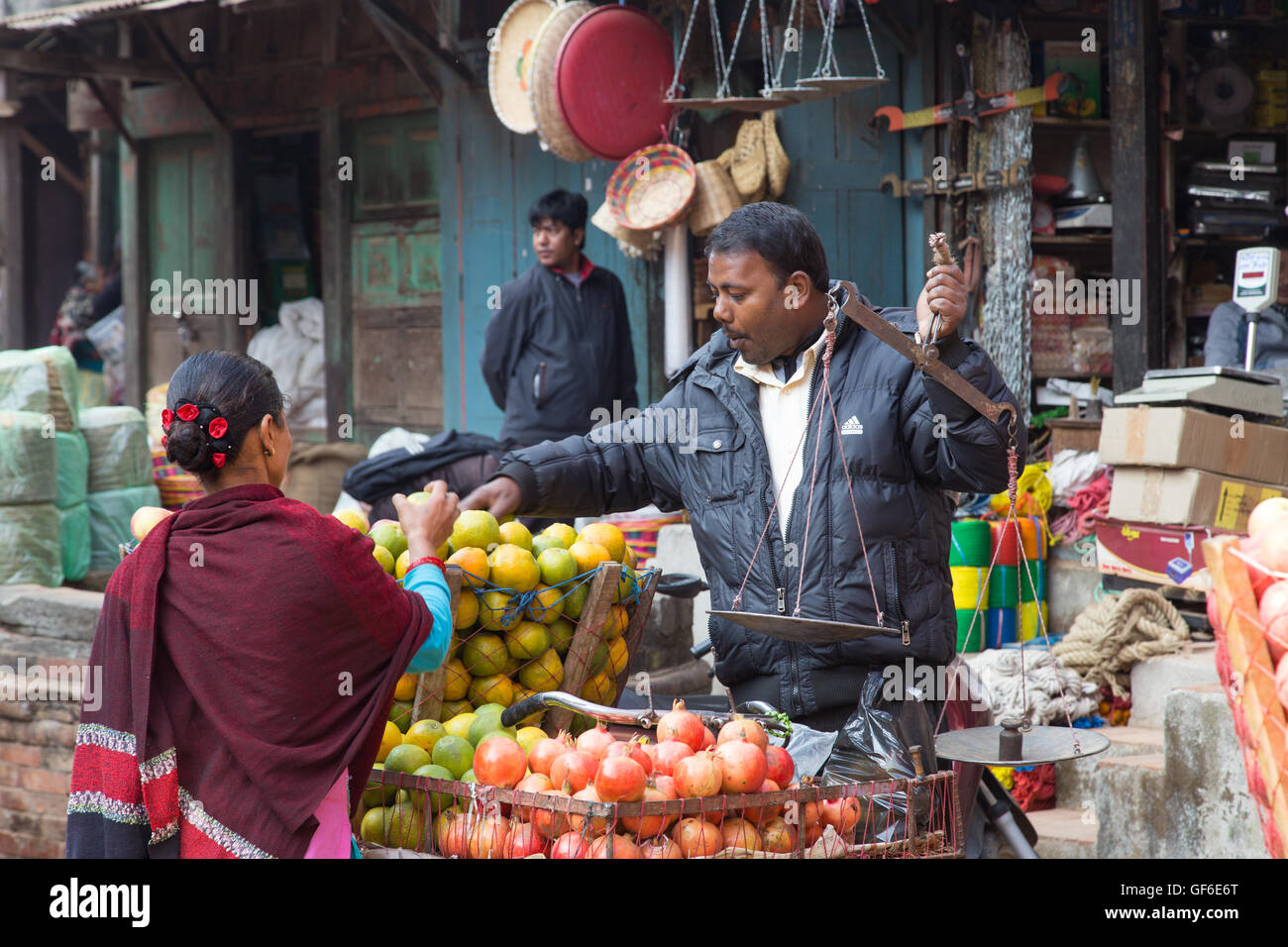 Bhaktapur, Népal - 5 décembre 2014 : vendeur de fruits avec un client dans la rue. Banque D'Images