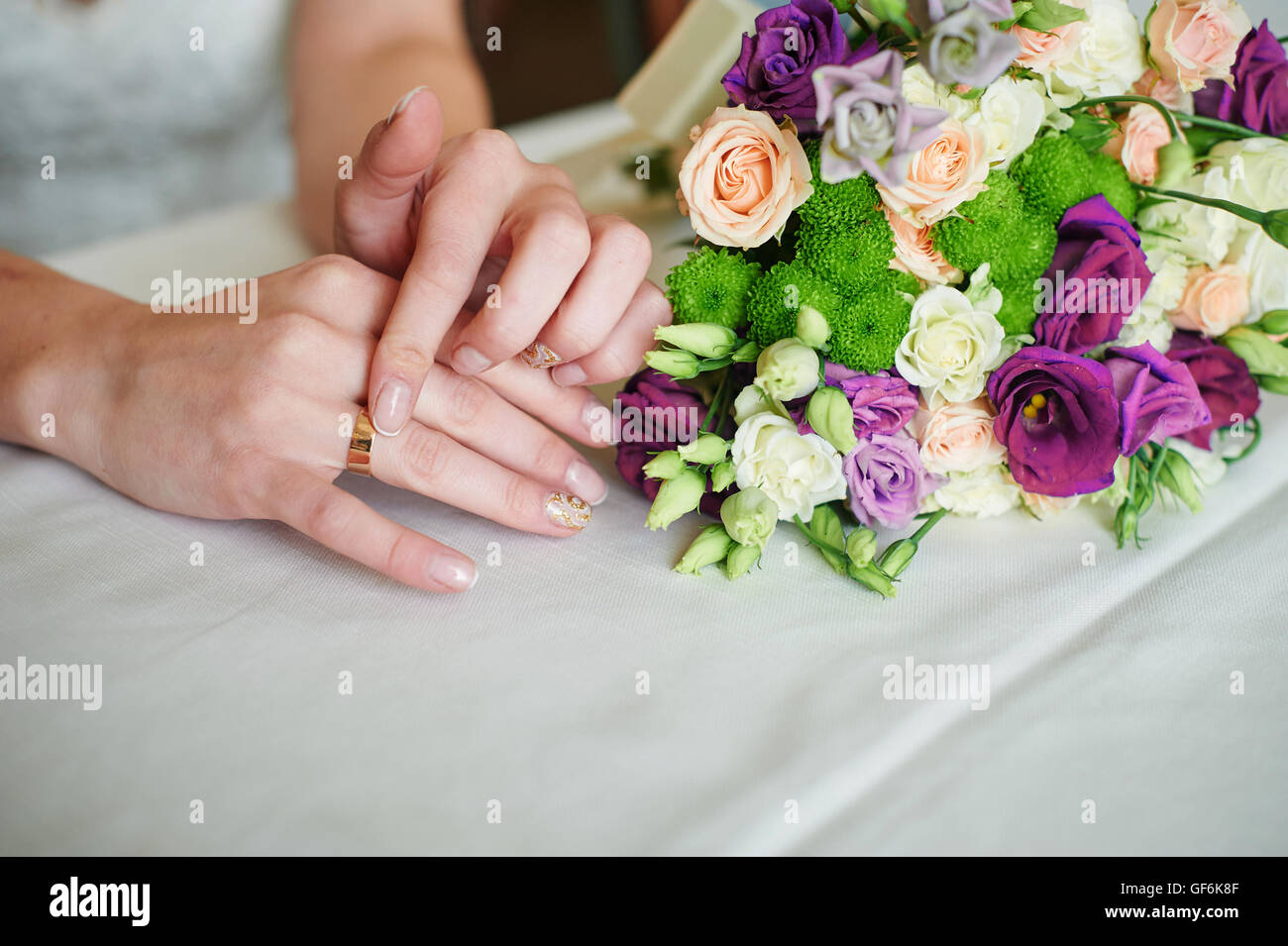 Mariée la main avec anneau d'or un bouquet de mariage sur la table Banque D'Images