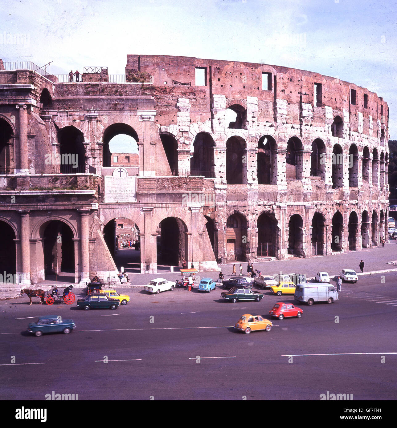 Années 1960, historique, Rome, Italie et les voitures garées devant l'immense Colisée, le plus grand et le plus célèbre amphithéâtre jamais construit. Banque D'Images