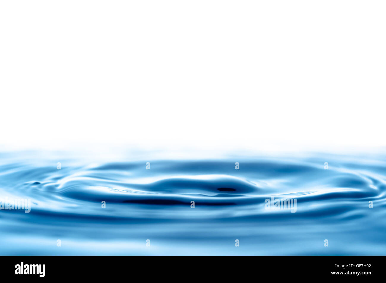 Des vagues dans l'eau après la chute d'une goutte Banque D'Images
