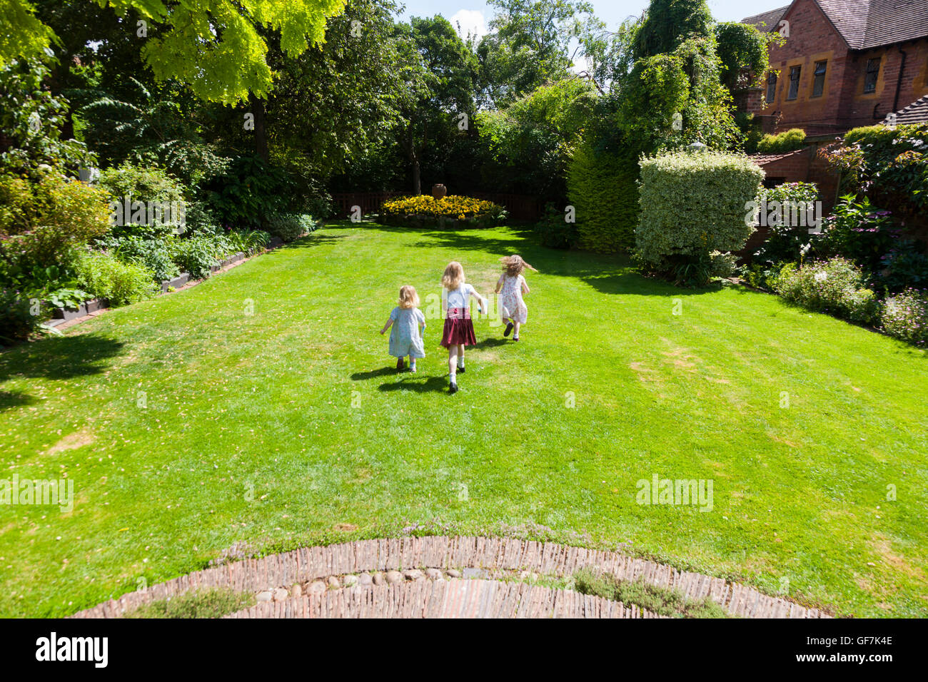 La maison et les jardins de Greyfriars avec 3 enfants / kids / kid en marche et de jouer sur la pelouse du jardin de l'herbe. Friar Street, Worcester. UK Banque D'Images