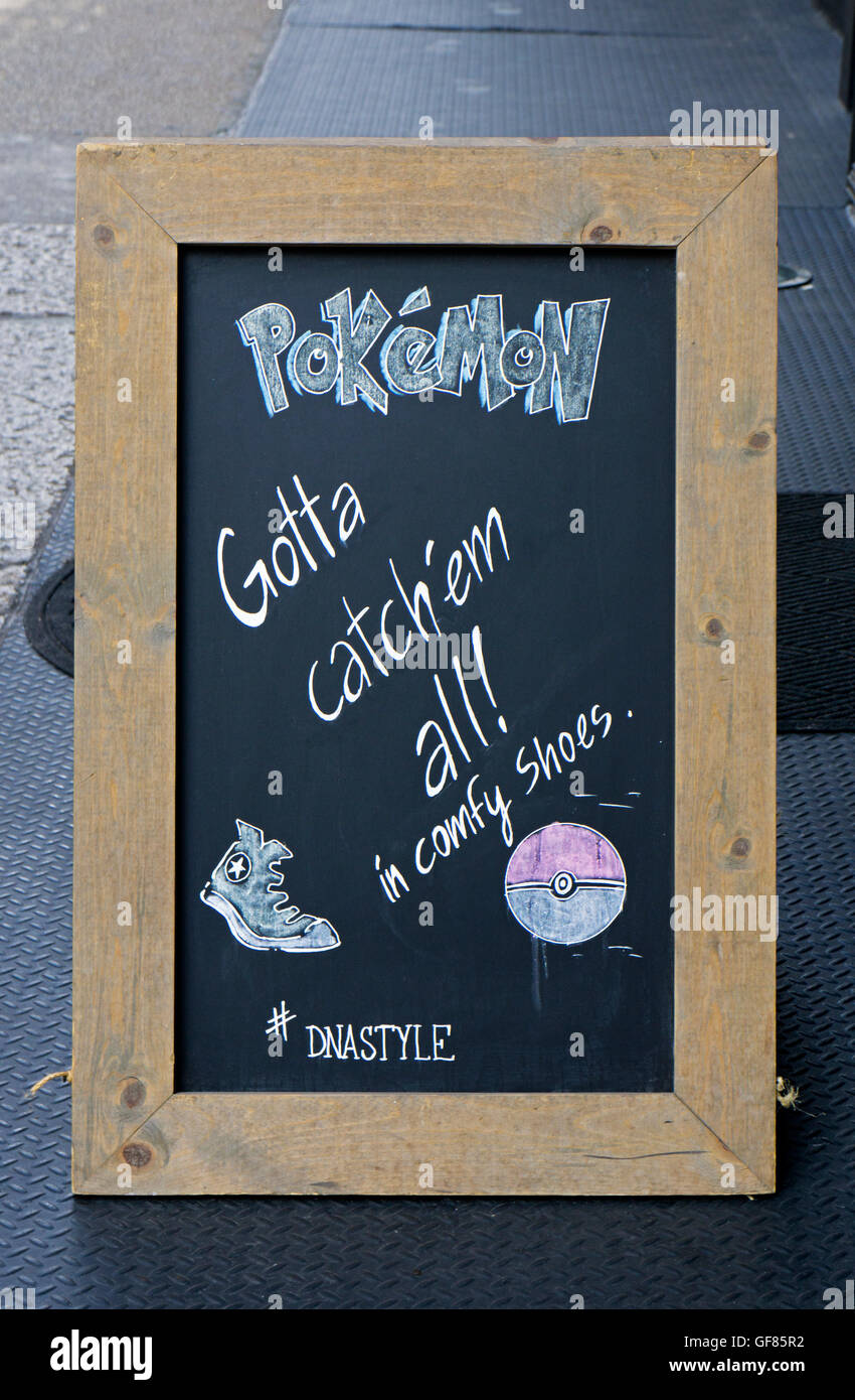 Un signe extérieur d'un magasin de chaussures à la mode dans le lower Manhattan encourageant les gens à être à l'aise tout en chassant Pokemon. Banque D'Images