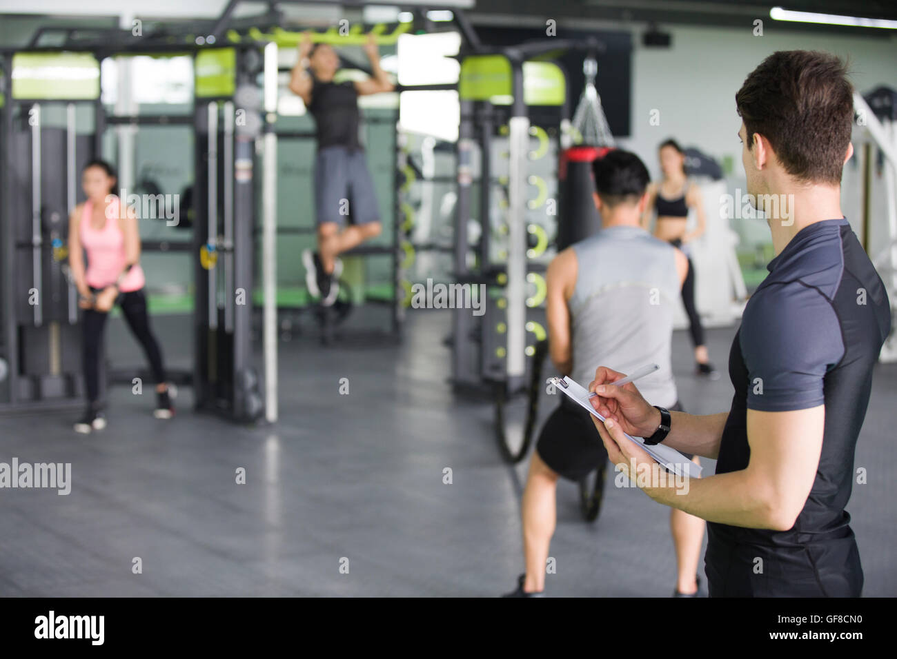 Instructeur de conditionnement physique avec presse-papiers à la salle de sport Banque D'Images