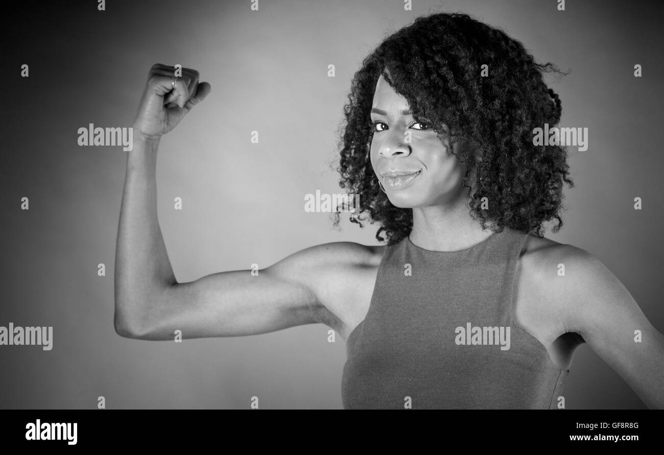 Modèle féminin jolie femme montrant avec force arm curl Banque D'Images