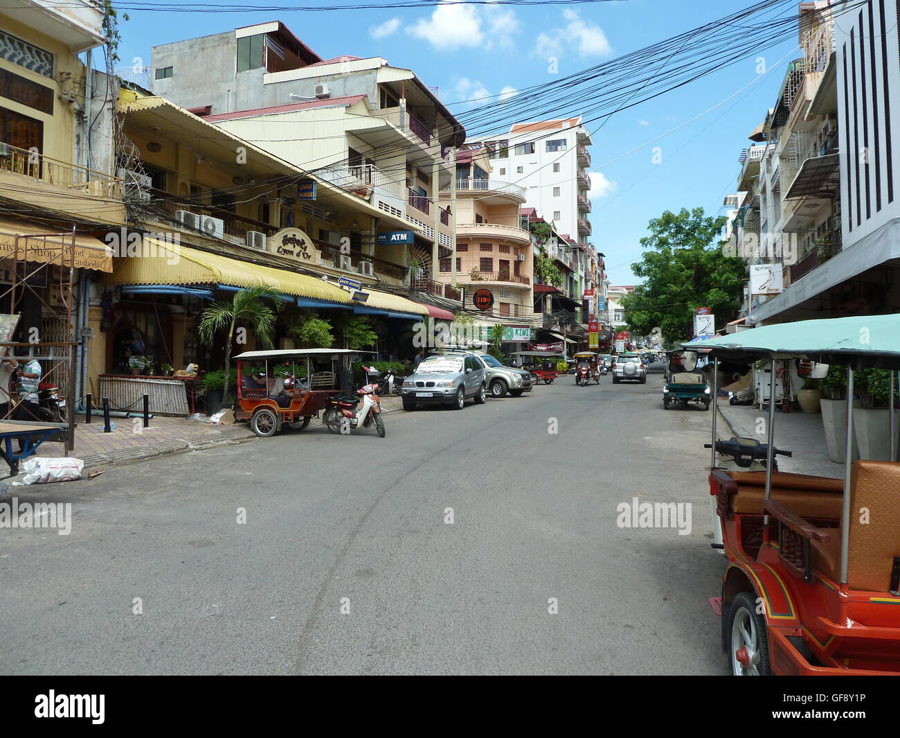 Street photo à Phnom Penh avec les gens qui voyagent dans les voitures et sur les motos. Très occupé et dynamique ville cambodgienne. Banque D'Images