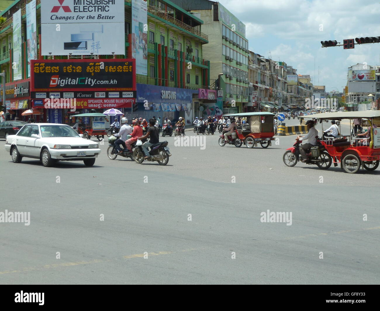 Street photo à Phnom Penh avec les gens qui voyagent dans les voitures et sur les motos. Très occupé et dynamique ville cambodgienne. Banque D'Images