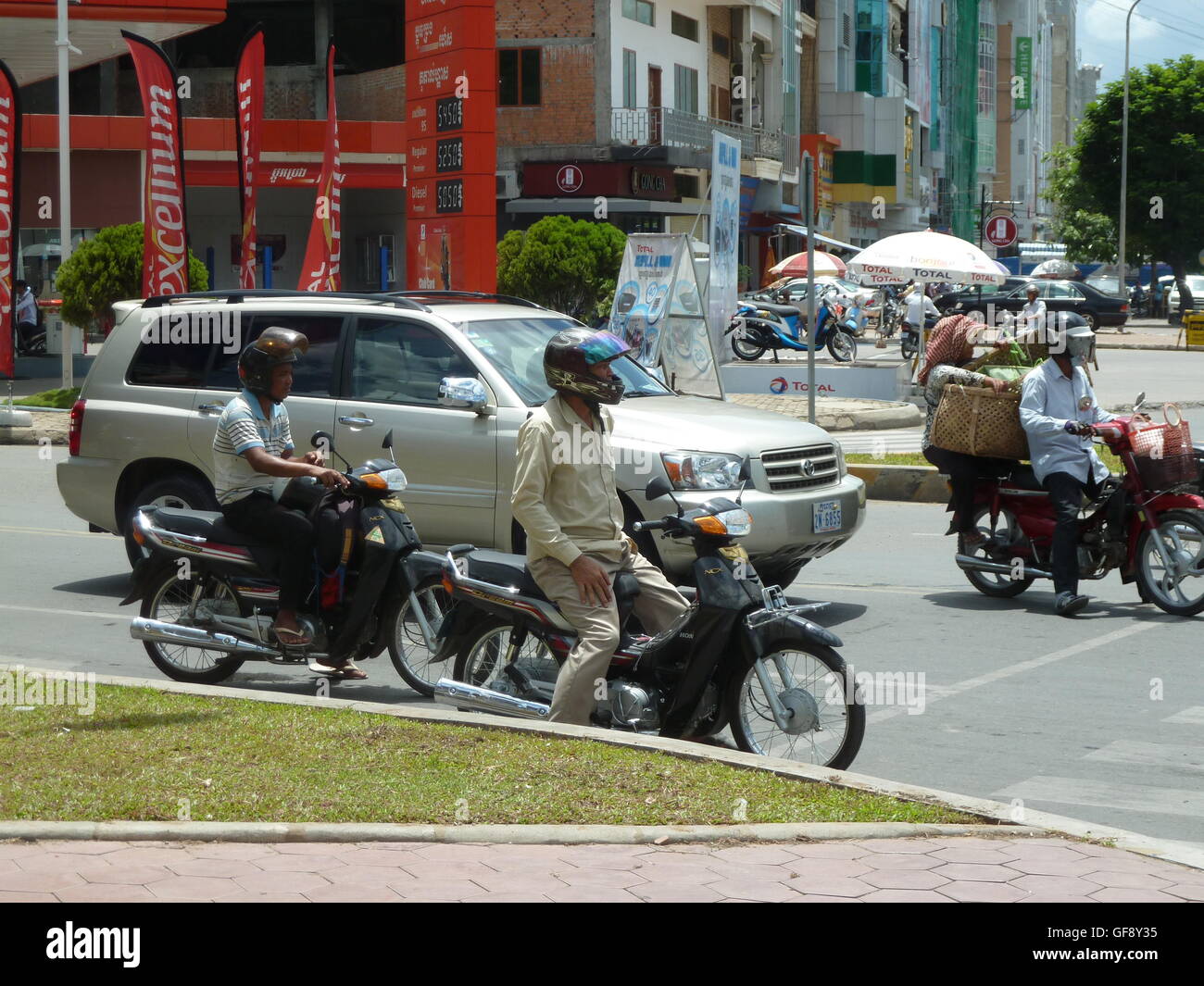 Street photo à Phnom Penh avec les gens qui voyagent dans les voitures et sur les motos. Très occupé et dynamique ville cambodgienne. Banque D'Images