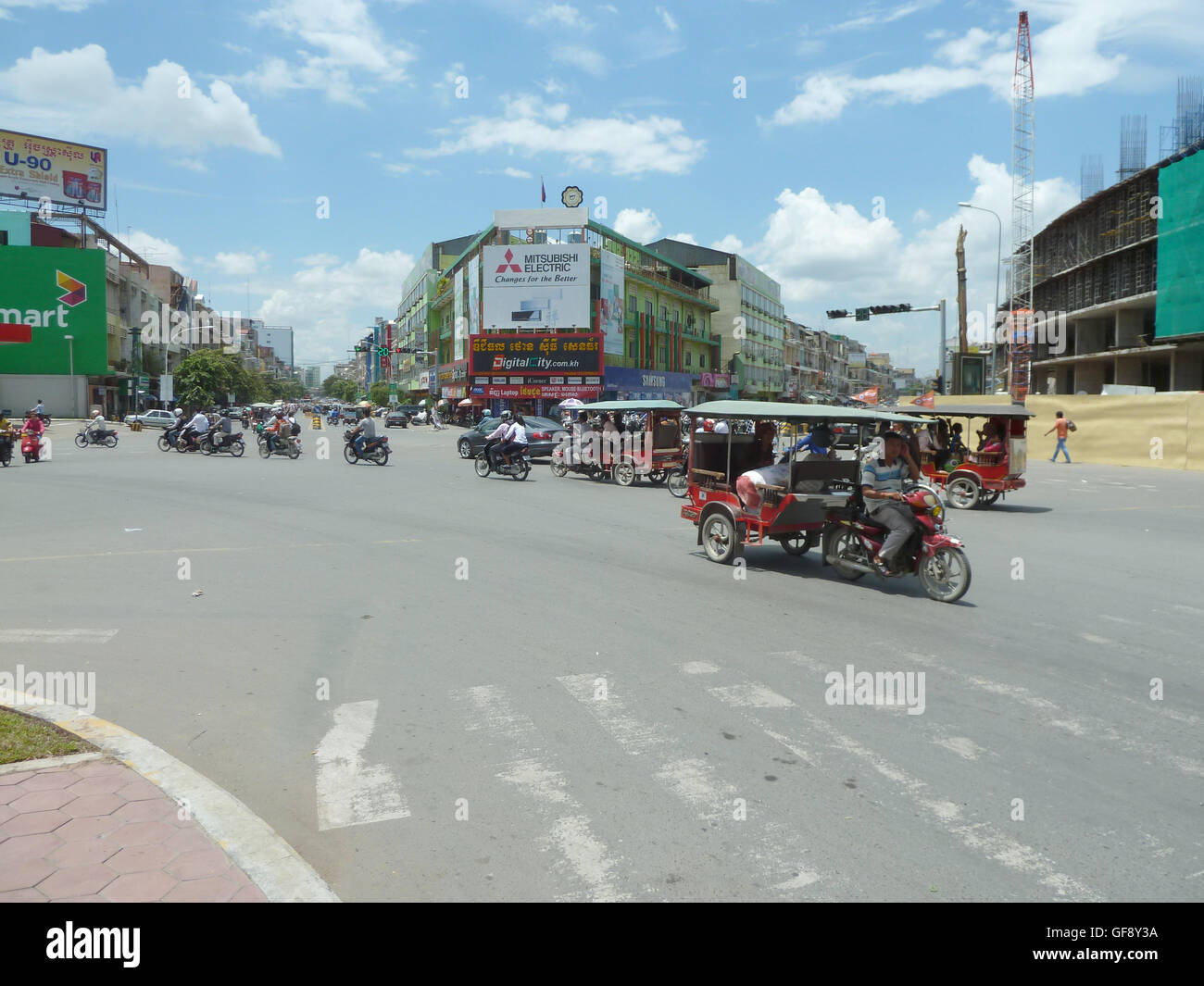 Street photo à Phnom Penh avec les gens qui voyagent dans les voitures et sur les motos. Très occupé et dynamique ville cambodgienne. Banque D'Images