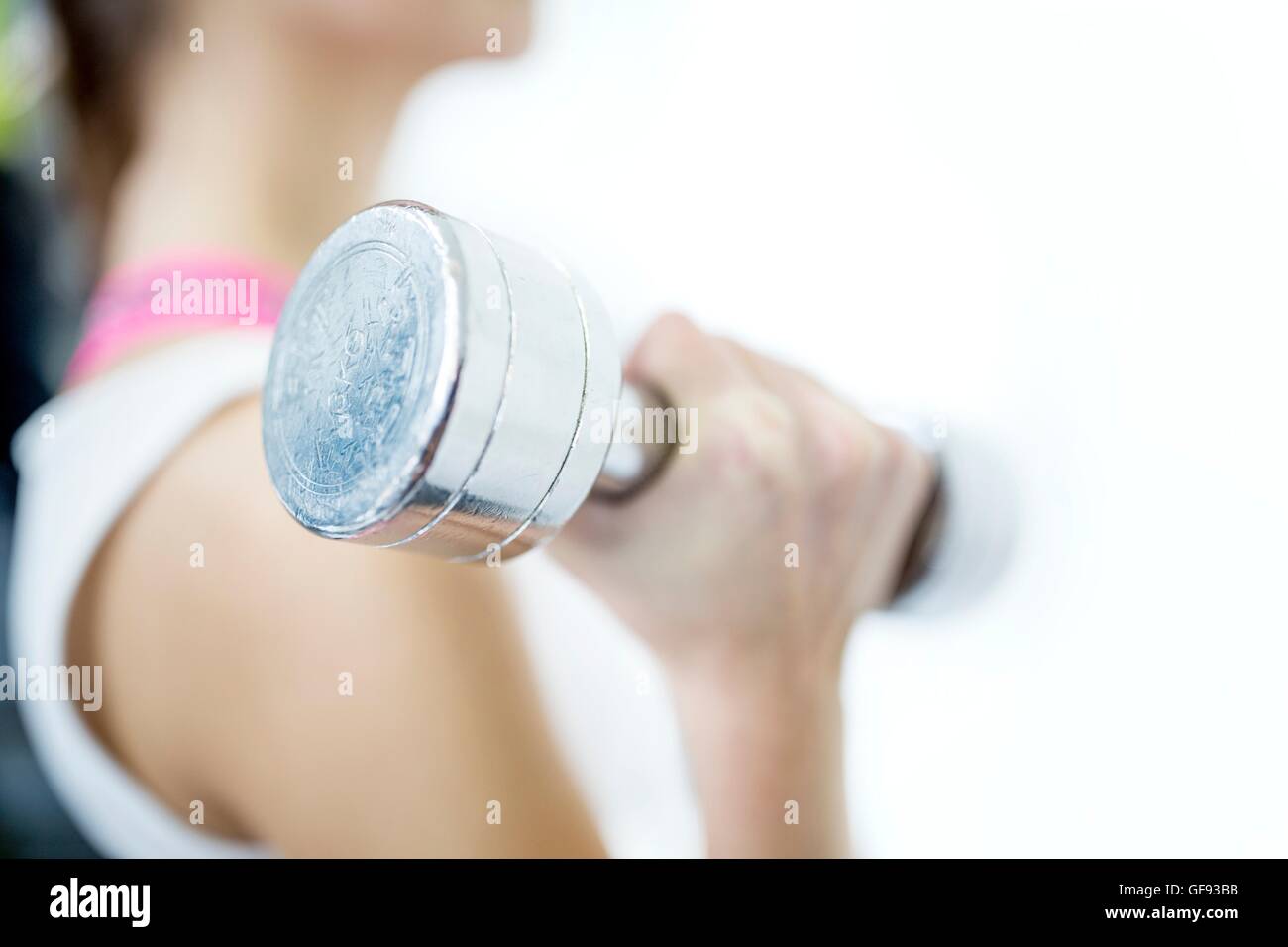 Parution de la propriété. Parution du modèle. Jeune femme travaillant avec haltère, close-up. Banque D'Images