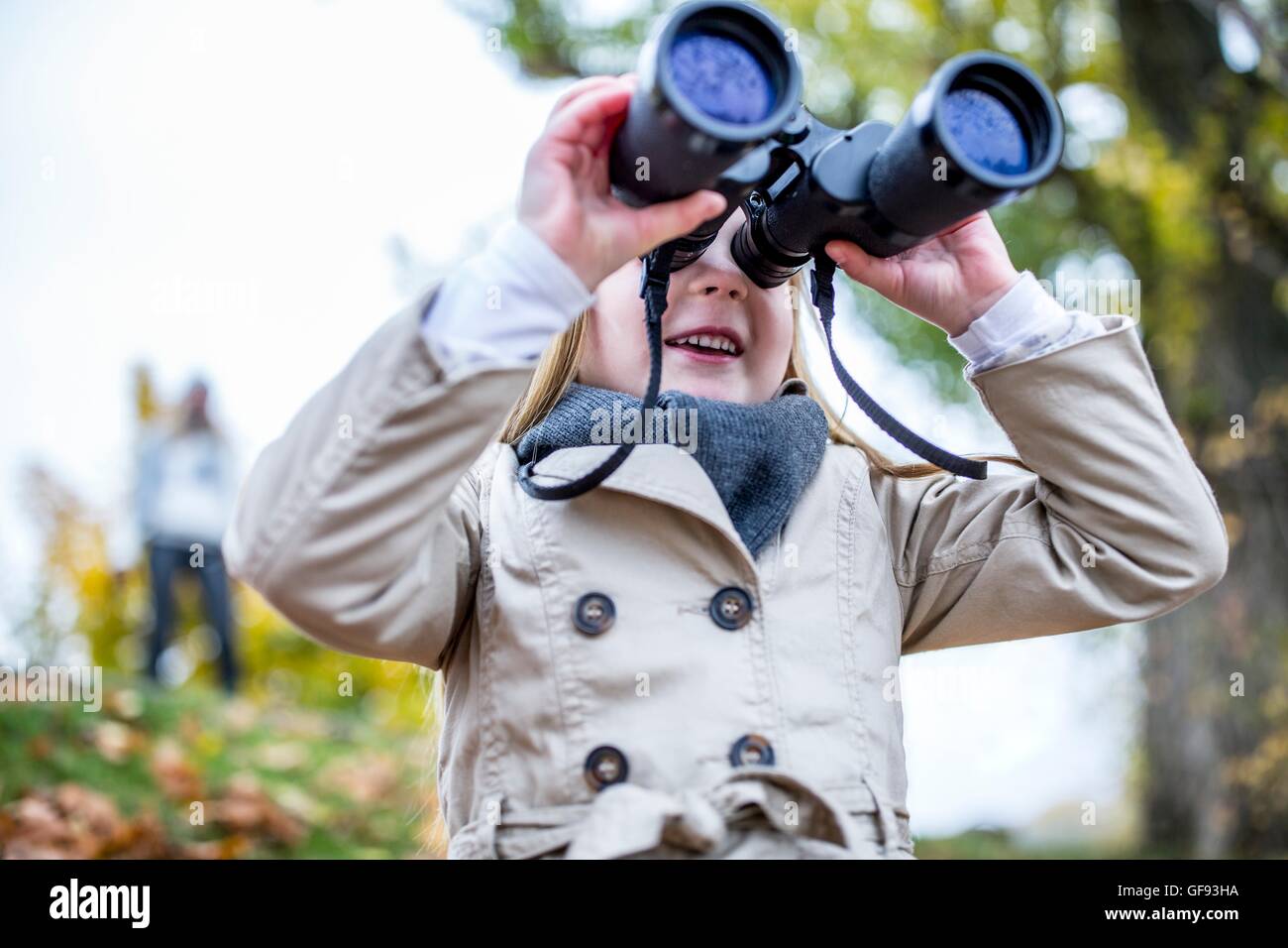 Parution du modèle. Girl looking through binoculars, close-up. Banque D'Images