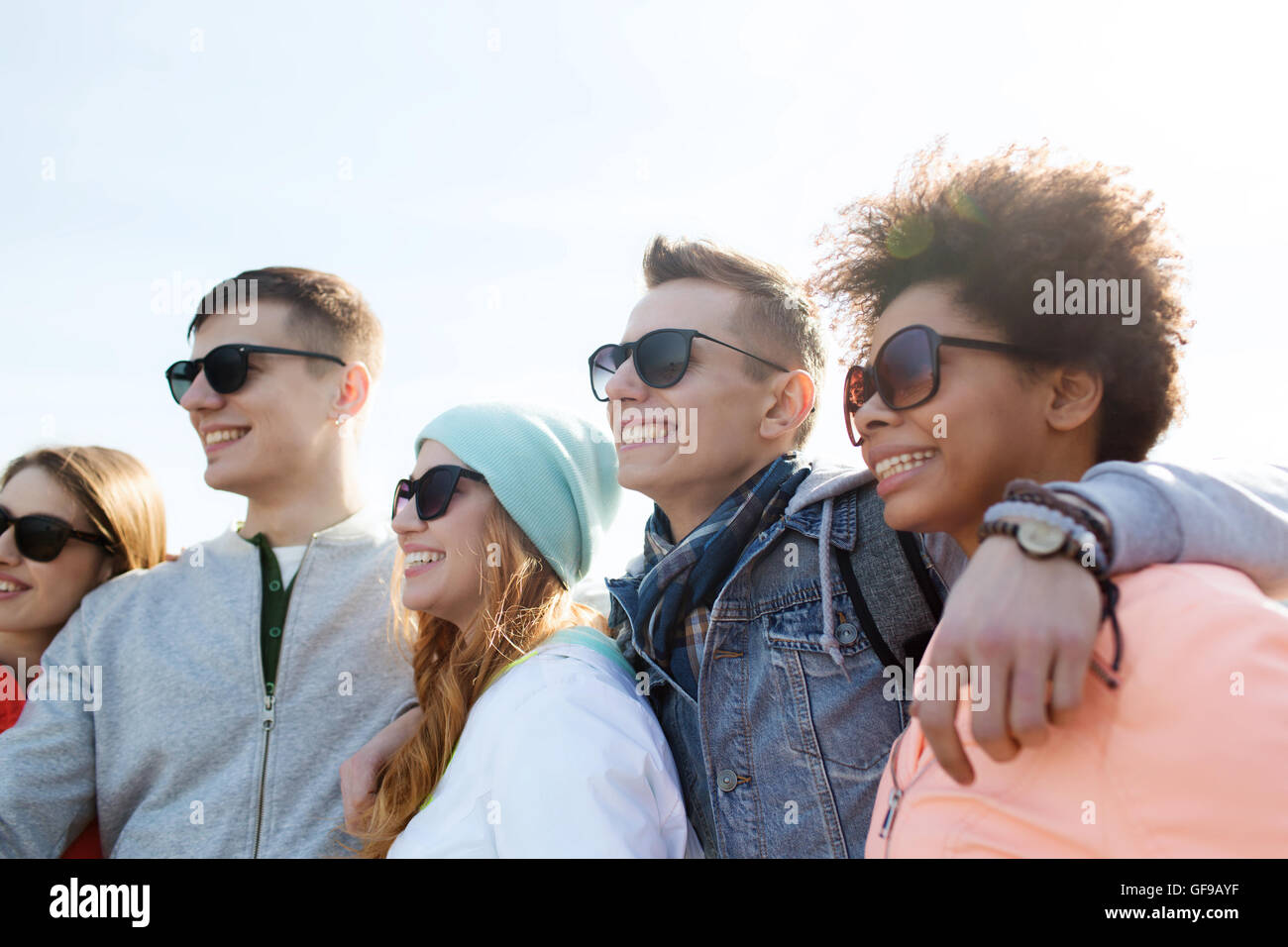 Heureux amis adolescents dans les tons hugging outdoors Banque D'Images