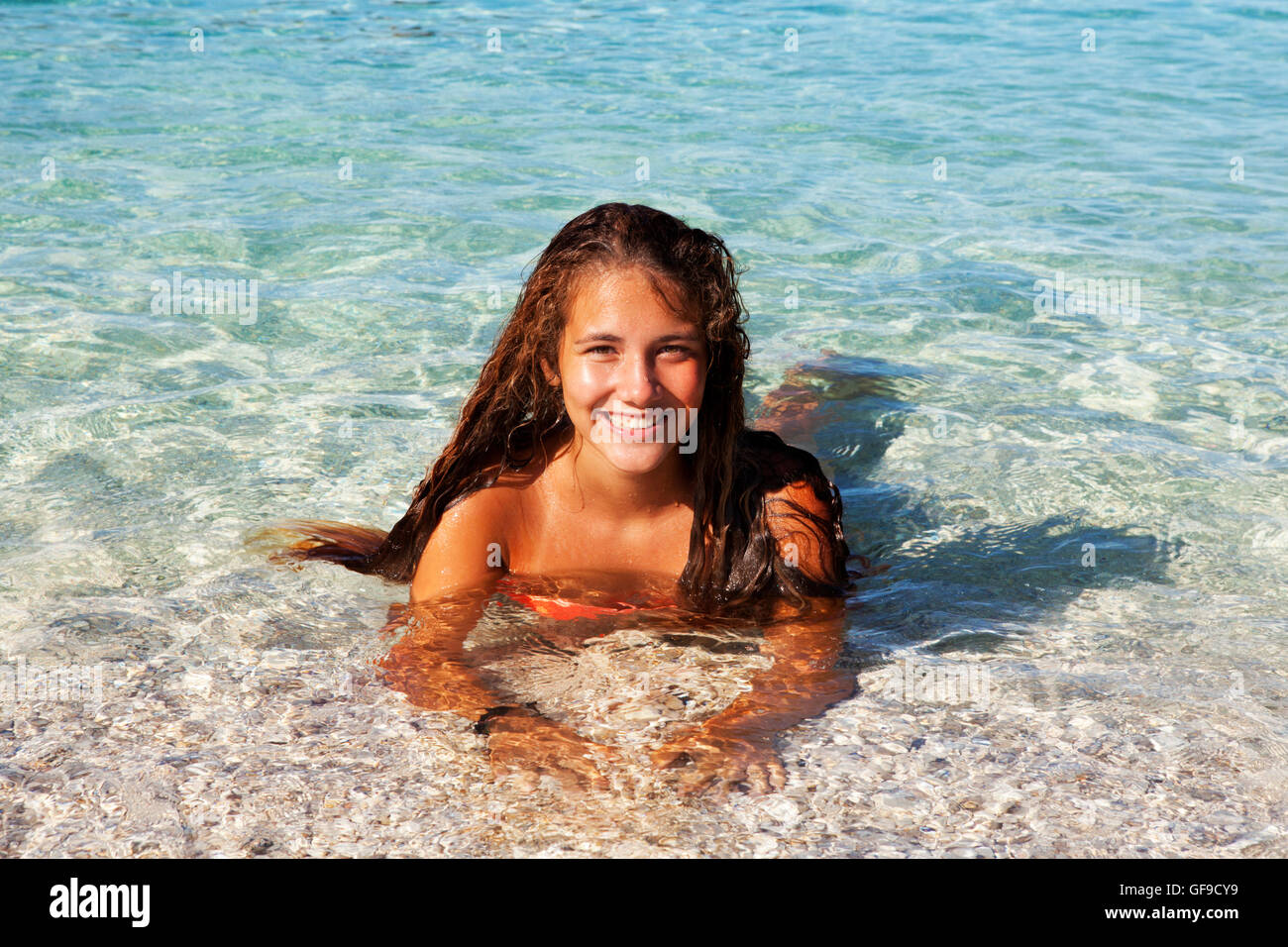 Jeune adolescent bronzé tourist baignade dans les eaux limpides de la mer Méditerranée à la plage d'Antisamos, l'île de Céphalonie, Grèce Banque D'Images