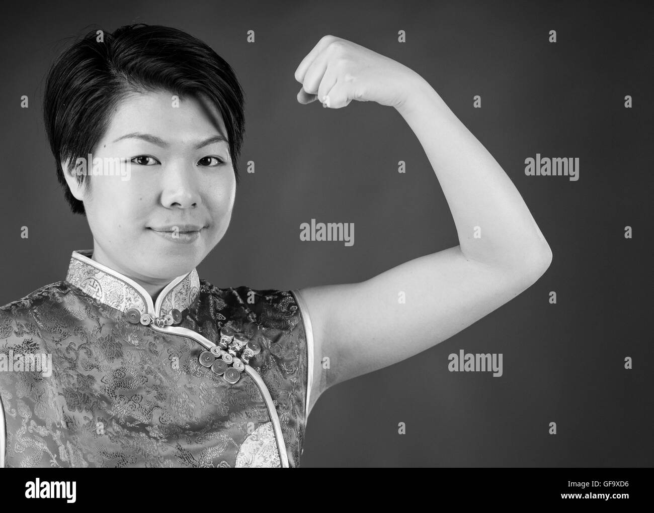 Modèle féminin jolie femme montrant avec force arm curl Banque D'Images