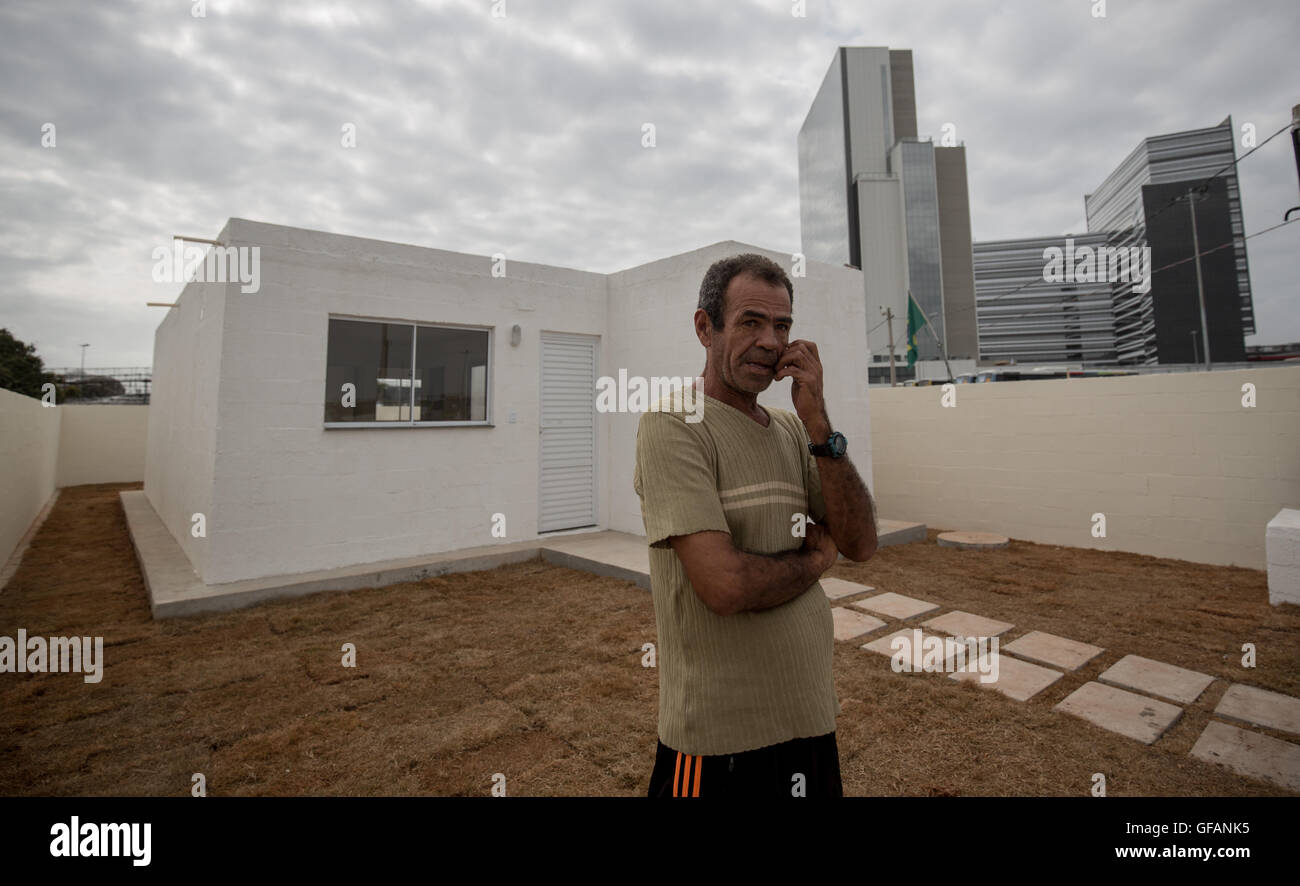 Rio de Janeiro, Brésil. 29 juillet, 2016. Joao Felix se tient juste en face de la nouvelle maison à Rio de Janeiro, Brésil, 29 juillet 2016. Dans la favela Vila Autodromo du Parc olympique à Rio, 20 des 700 familles a une résistance massive qu'ils ont été autorisés à rester. Il est vrai que leurs maisons ont été formulées - et maintenant ils vivent directement par les installations sportives. Photo : MICHAEL KAPPELER/dpa/Alamy Live News Banque D'Images