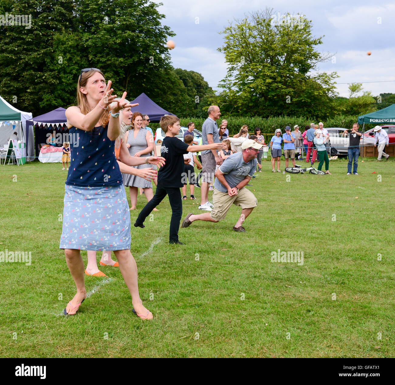 Le plaisir et le jeu à l'assemblée annuelle de l'horticulture et kermesse spectacle à Damerham, Hampshire, Royaume-Uni. Lancer et Attraper l'œuf est d'événements populaires mais jeu désordonné. Banque D'Images