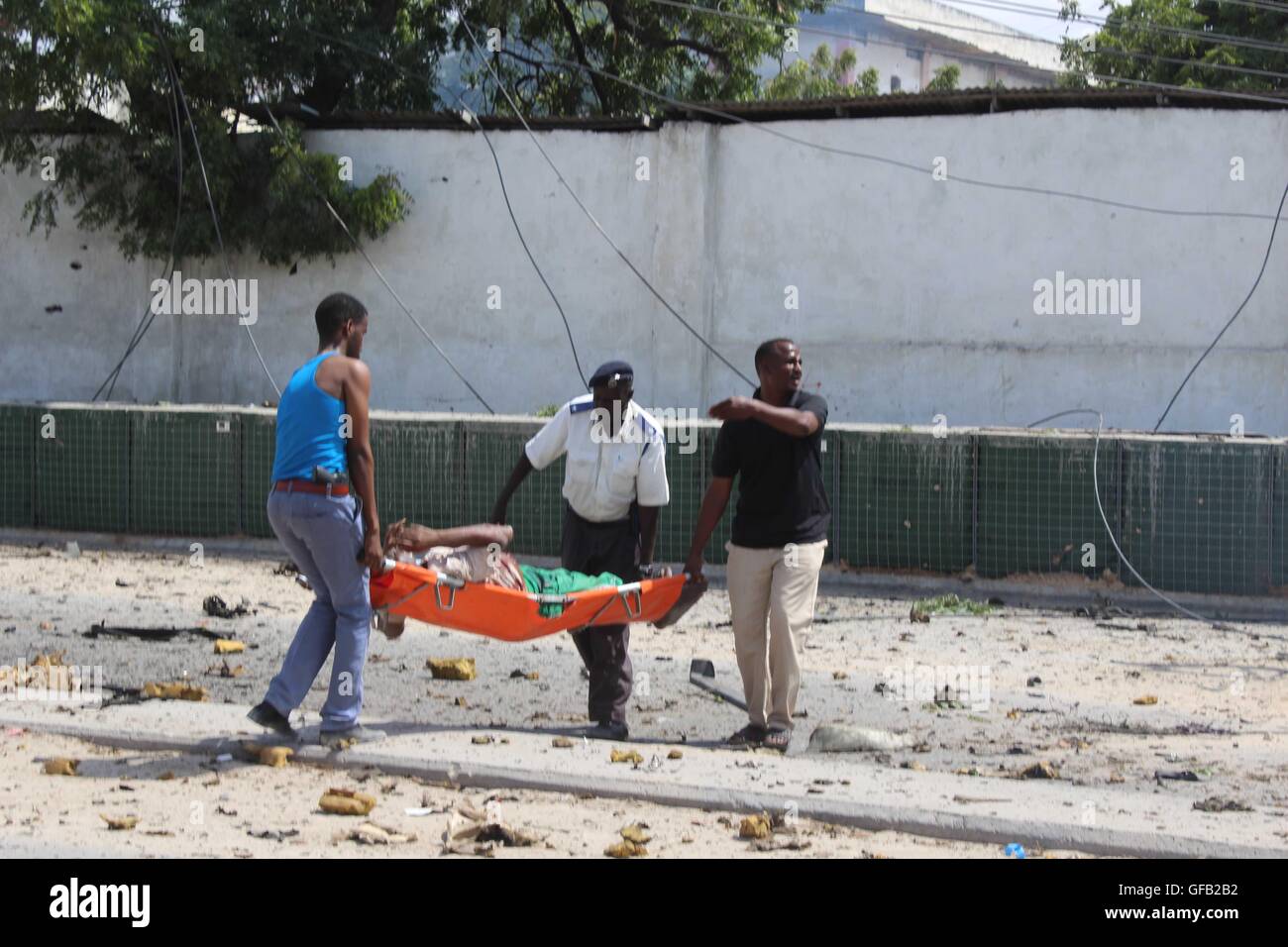 Mogadiscio, Somalie. 31 juillet, 2016. Les gens portent un blessé après l'explosion d'une voiture piégée à Mogadiscio, capitale de la Somalie, le 31 juillet 2016. Au moins cinq personnes ont été tuées et plusieurs autres ont été blessées dimanche dans voiture lits jumeaux à la bombe au siège des enquêtes criminelles (CID) dans la capitale de Mogadiscio. Credit : Faisal Miu/Xinhua/Alamy Live News Banque D'Images