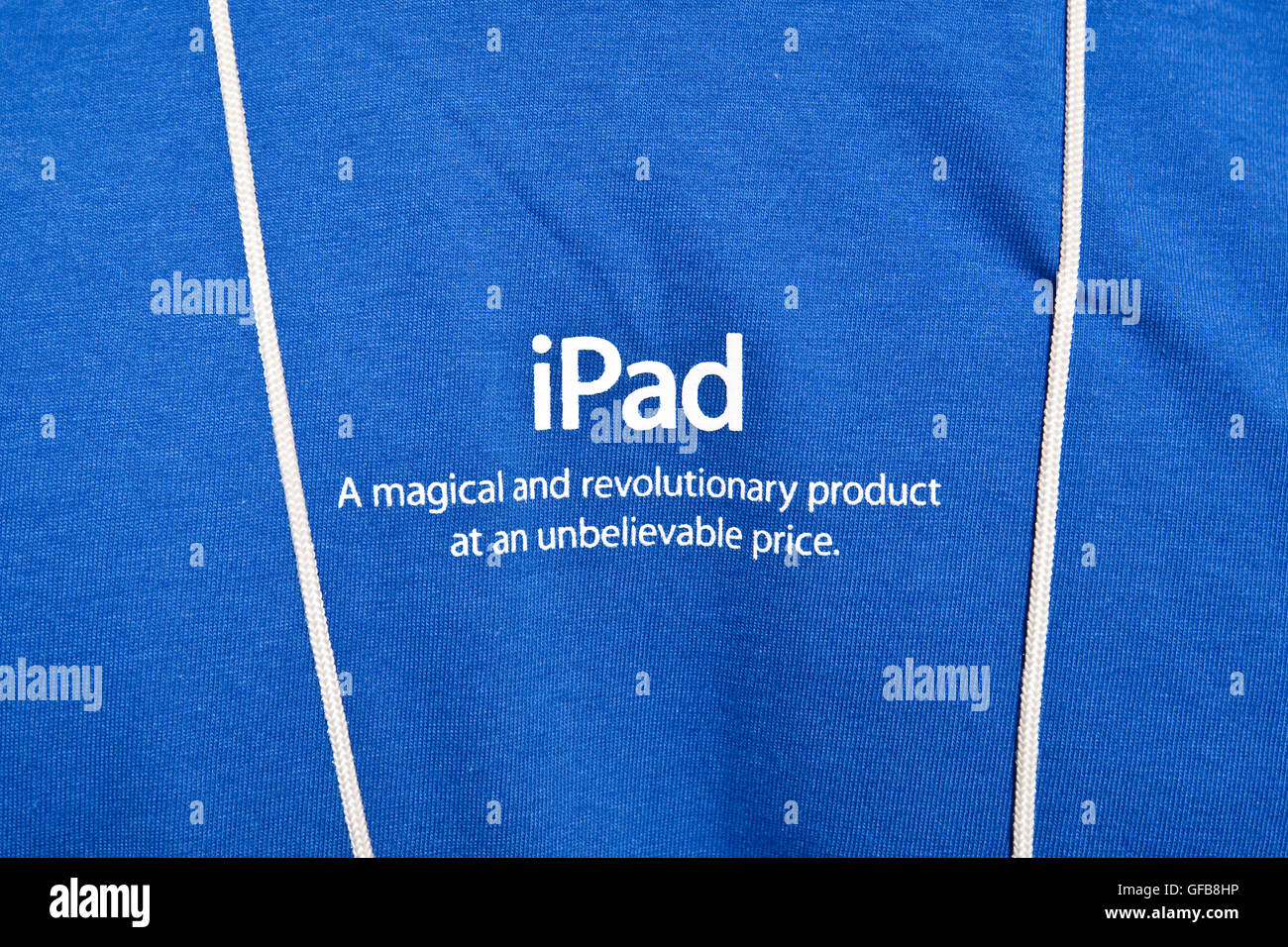 Détail tourné d'un employé de l'Apple store's blue t-shirt avec une inscription qui lit 'iPad. Un produit magique et révolutionnaire Banque D'Images