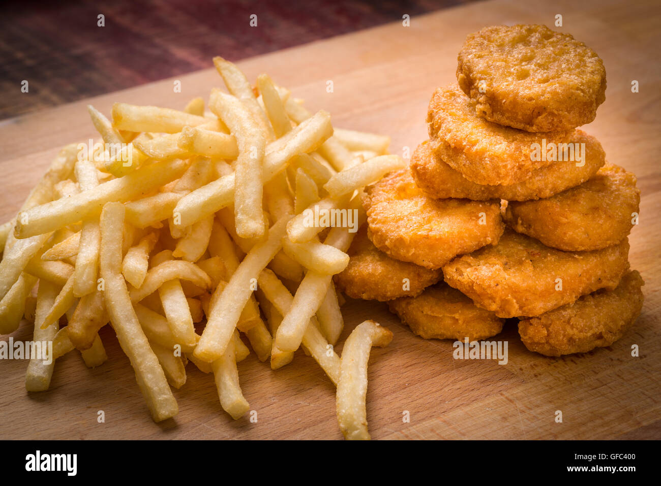 Golden brown Chicken Nuggets et frites sur un fond de bois Banque D'Images