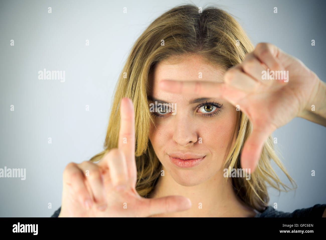 Modèle féminin jolie femme sur fond plein avec copie espace encadrement photo geste Banque D'Images