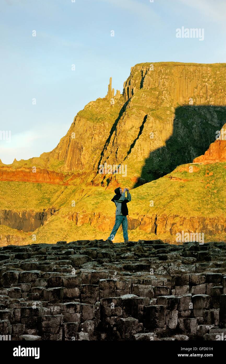 La Chaussée des Géants, en Irlande du Nord. Couple de touristes de prendre des photos sur les formations de roche de basalte connu sous le nom de Grand Causeway Banque D'Images