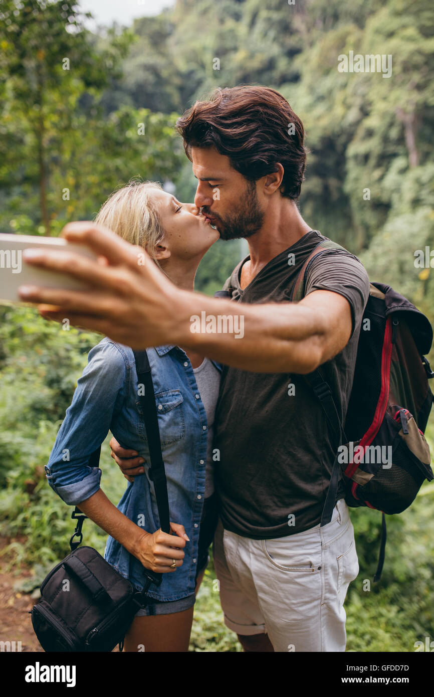 Loving couple taking self portrait et avec leur téléphone cellulaire. Couple in love prendre des auto photo en forêt. Banque D'Images