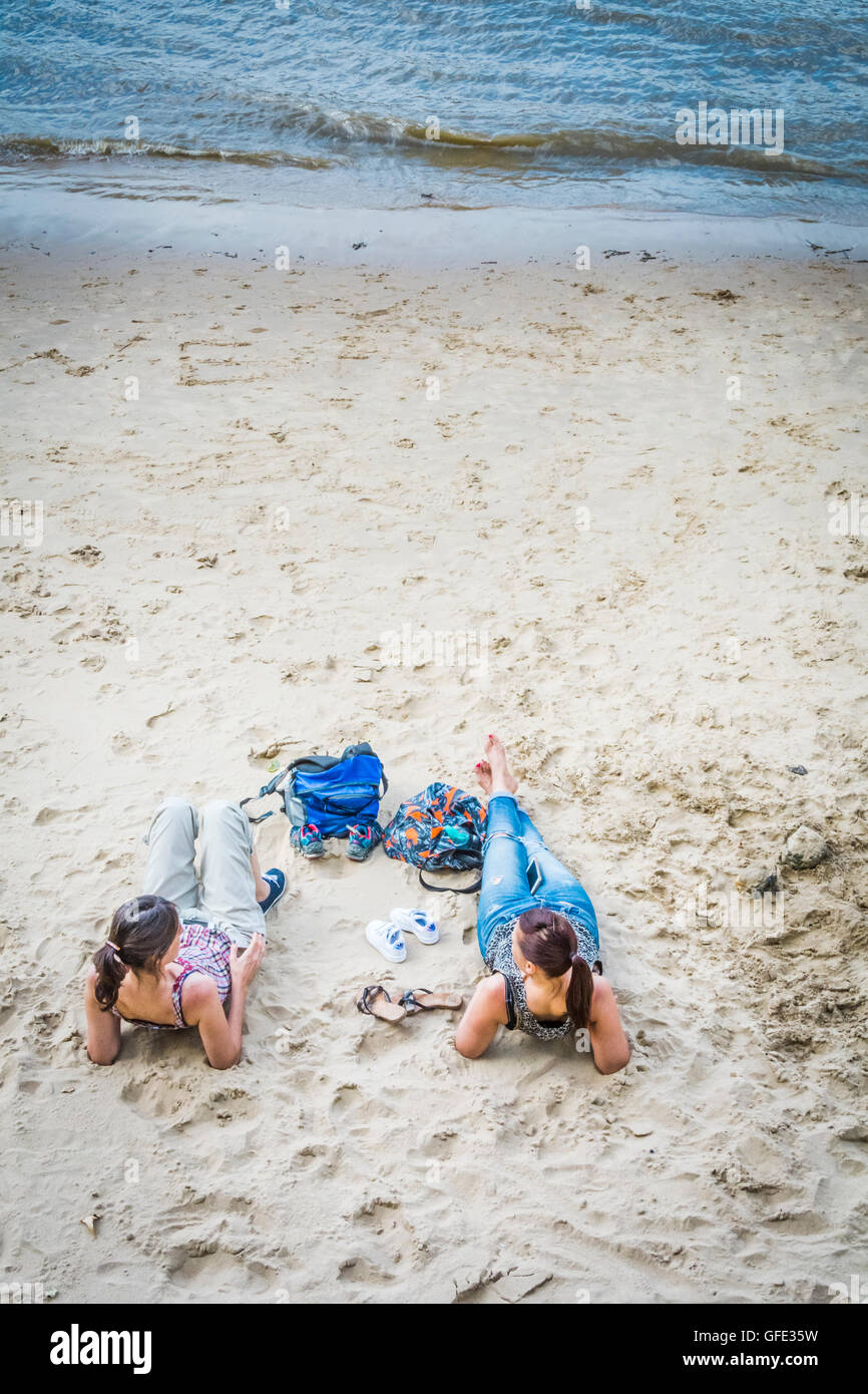 Deux femmes en train de bronzer sur la plage sur la rive sud de Londres Banque D'Images