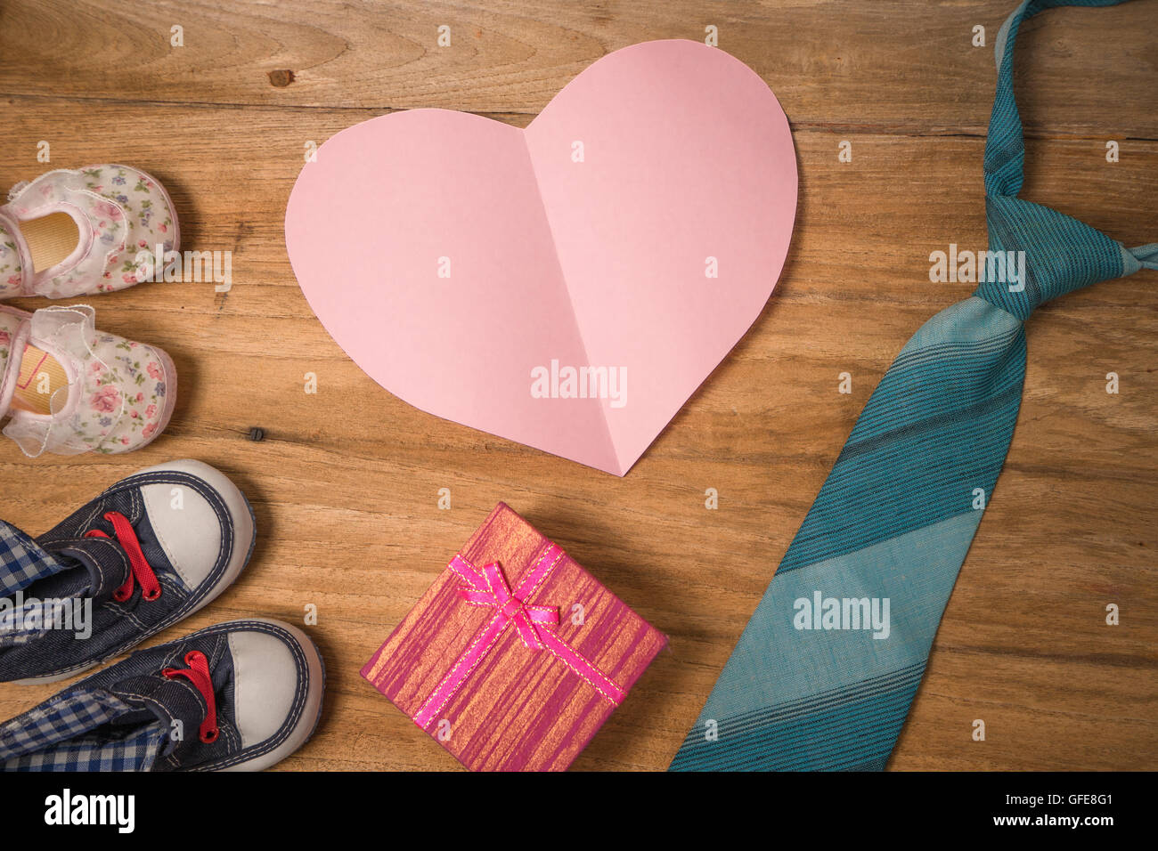 Daddy's boots ,chaussures de bébé ,coeurs Textile cadeaux cravate bleu ,et sur fond de bois .pères jours concept ,couleur vintage Banque D'Images