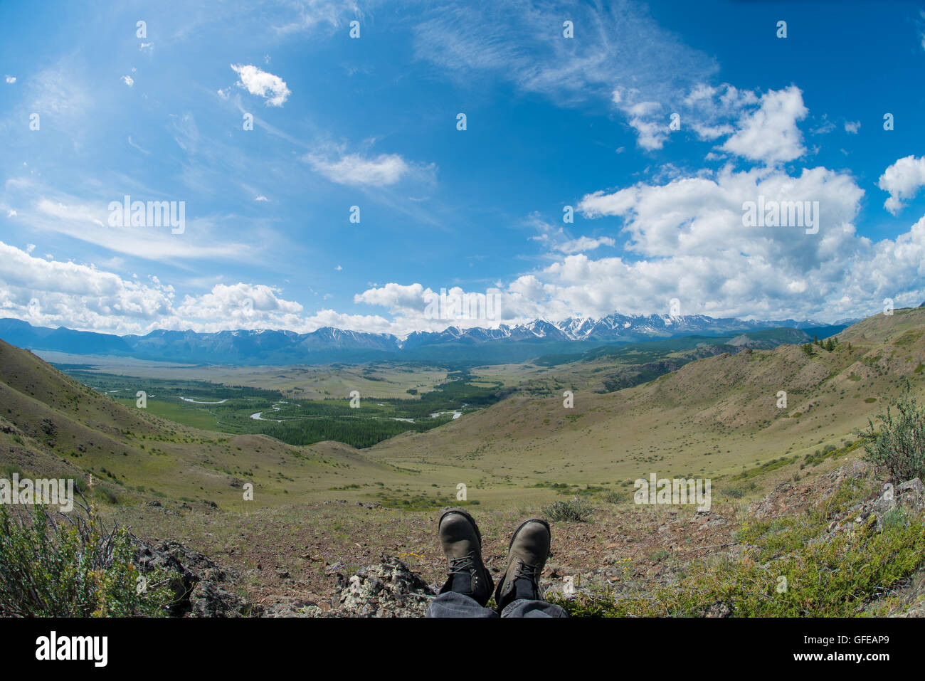 Pieds dans les chaussures en toile de fond des montagnes Banque D'Images