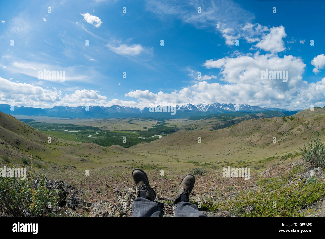 Pieds dans les chaussures en toile de fond des montagnes Banque D'Images